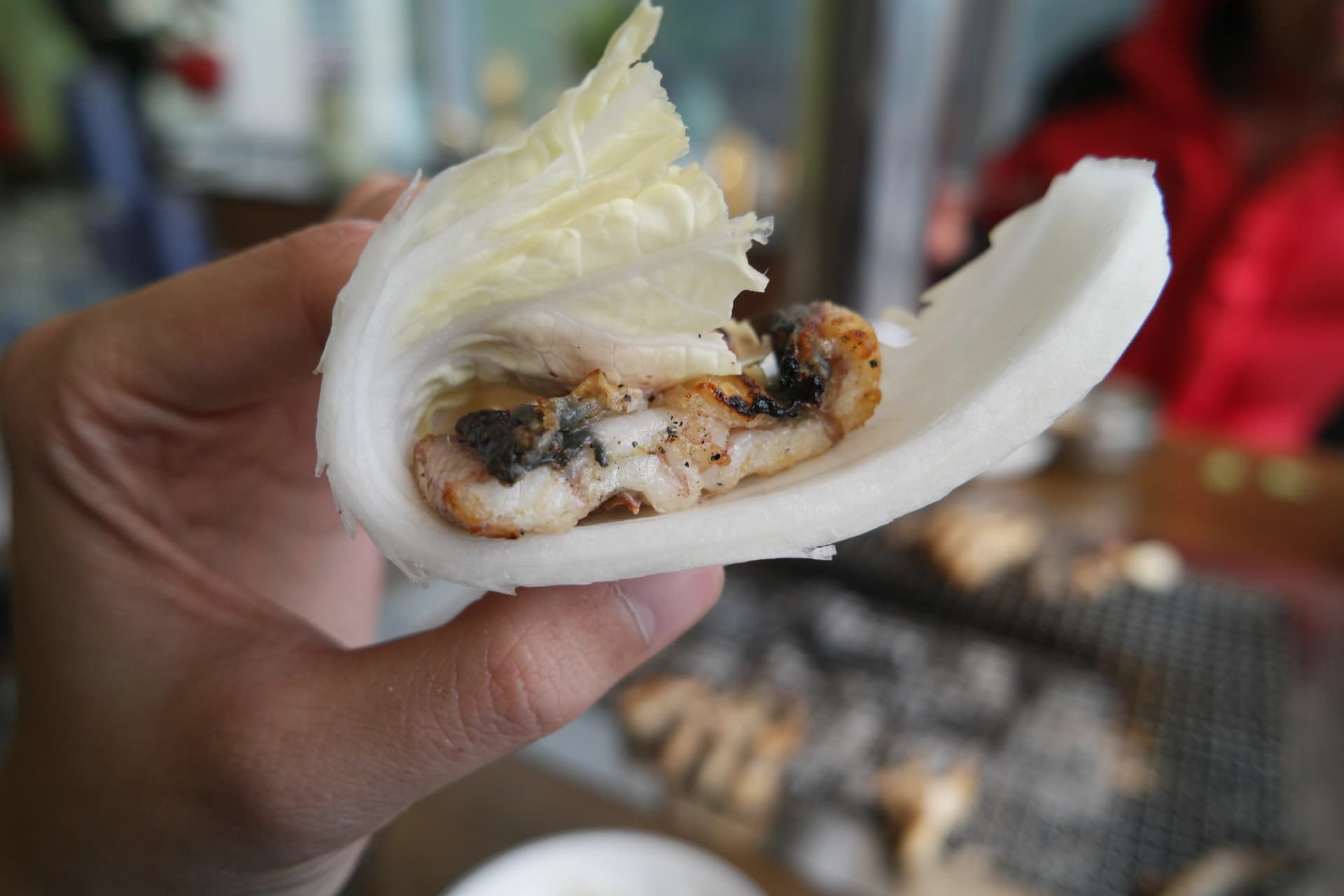 얇게 썬 무에 배추와 장어를 올려 싸먹는 모습 - 무의 아삭함이 장어와 잘 어울린다 | 하이제이에스비