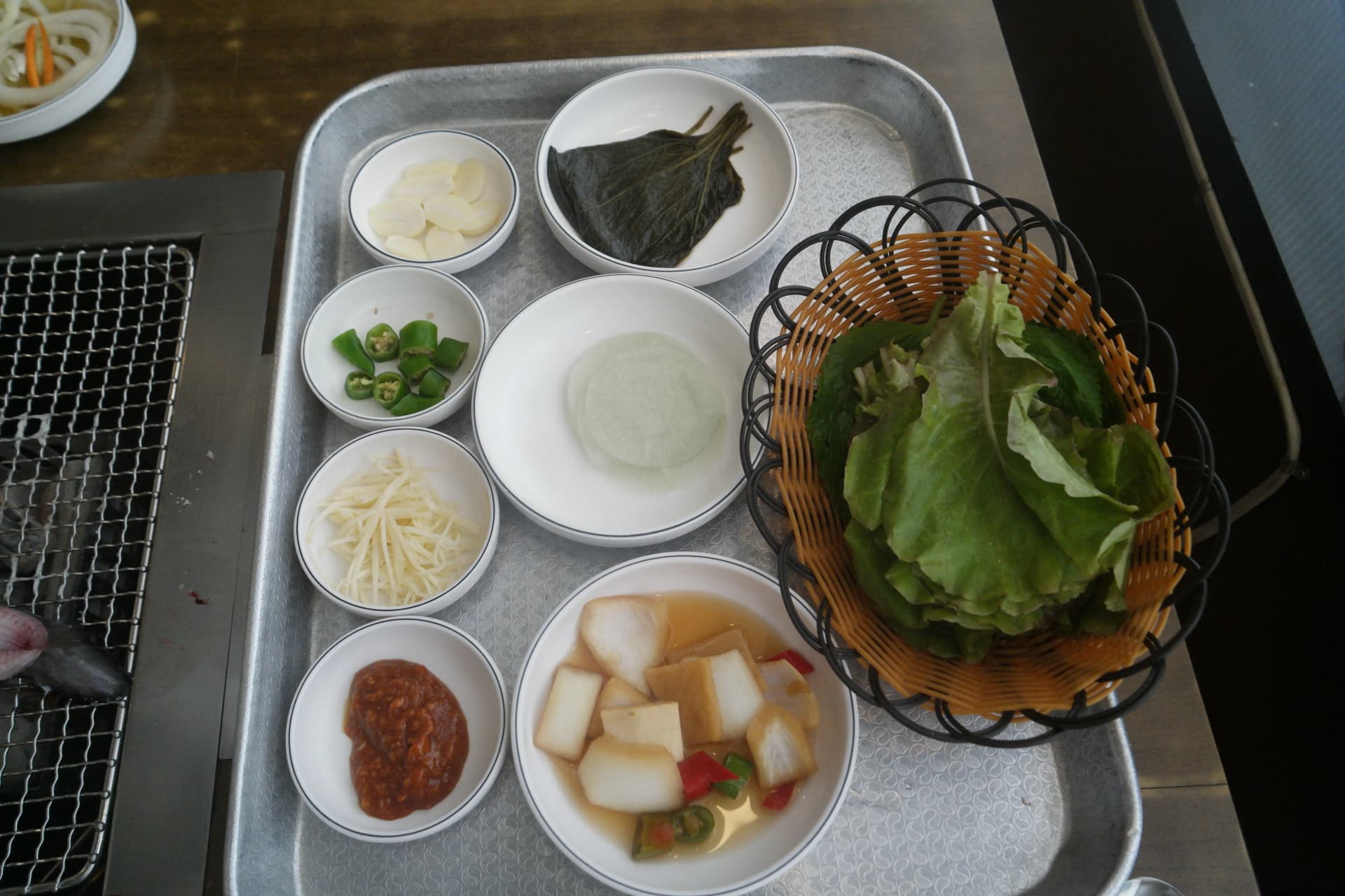 민물장어와 함께 제공되는 반찬 트레이 전체 모습 - 상추 깻잎 마늘 청양고추 생강 깻잎절임 깍두기 쌈장 | 하이제이에스비