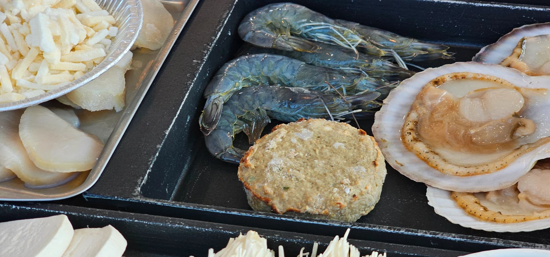 큼직한 새우와 해물전 키조개 관자 치즈가 불판 위에 놓인 클로즈업 | 하이제이에스비