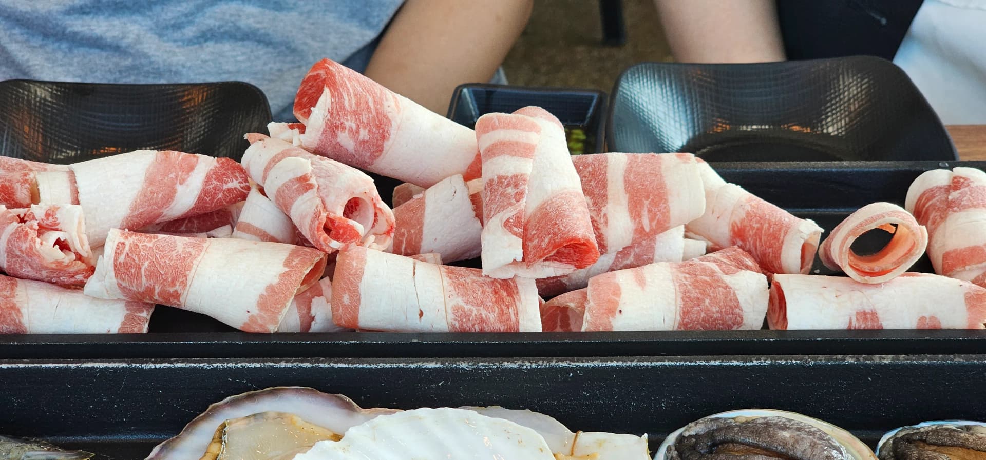 얇게 썬 차돌박이 한우 빨간 살코기 사이에 하얀 지방층이 층층이 보이는 접시 | 하이제이에스비