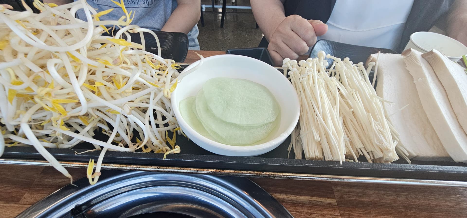 물에 담근 라이스페이퍼와 팽이버섯 두부가 나란히 놓인 사이드 접시 | 하이제이에스비