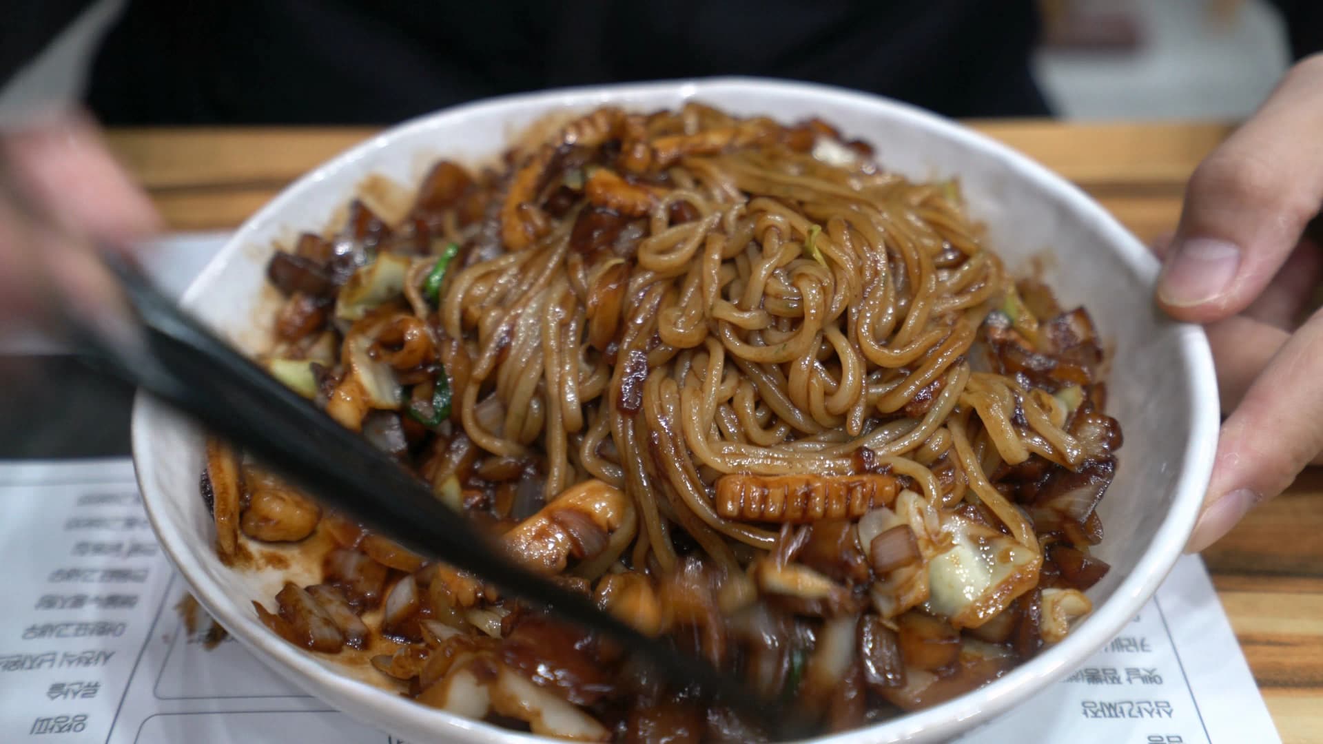 مرحلة متقدّمة من خلط الكانجاجانغ، كل النودلز صارت بنّية داكنة والحشوة اندمجت بين الشعيرات وأطراف الوعاء عليها آثار صوص