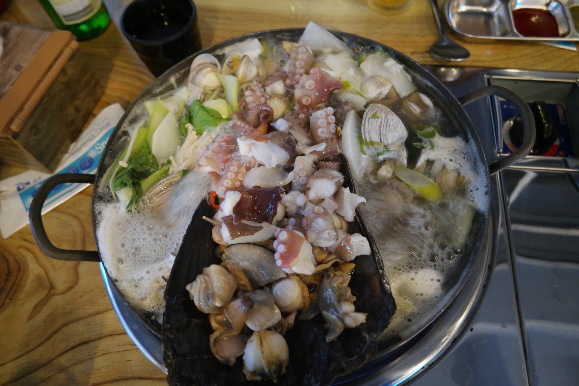 한국 조개찜 전체 냄비 샷 — 가리비 키조개 문어 각종 조개가 모두 익은 완성된 조개찜 | 하이제이에스비