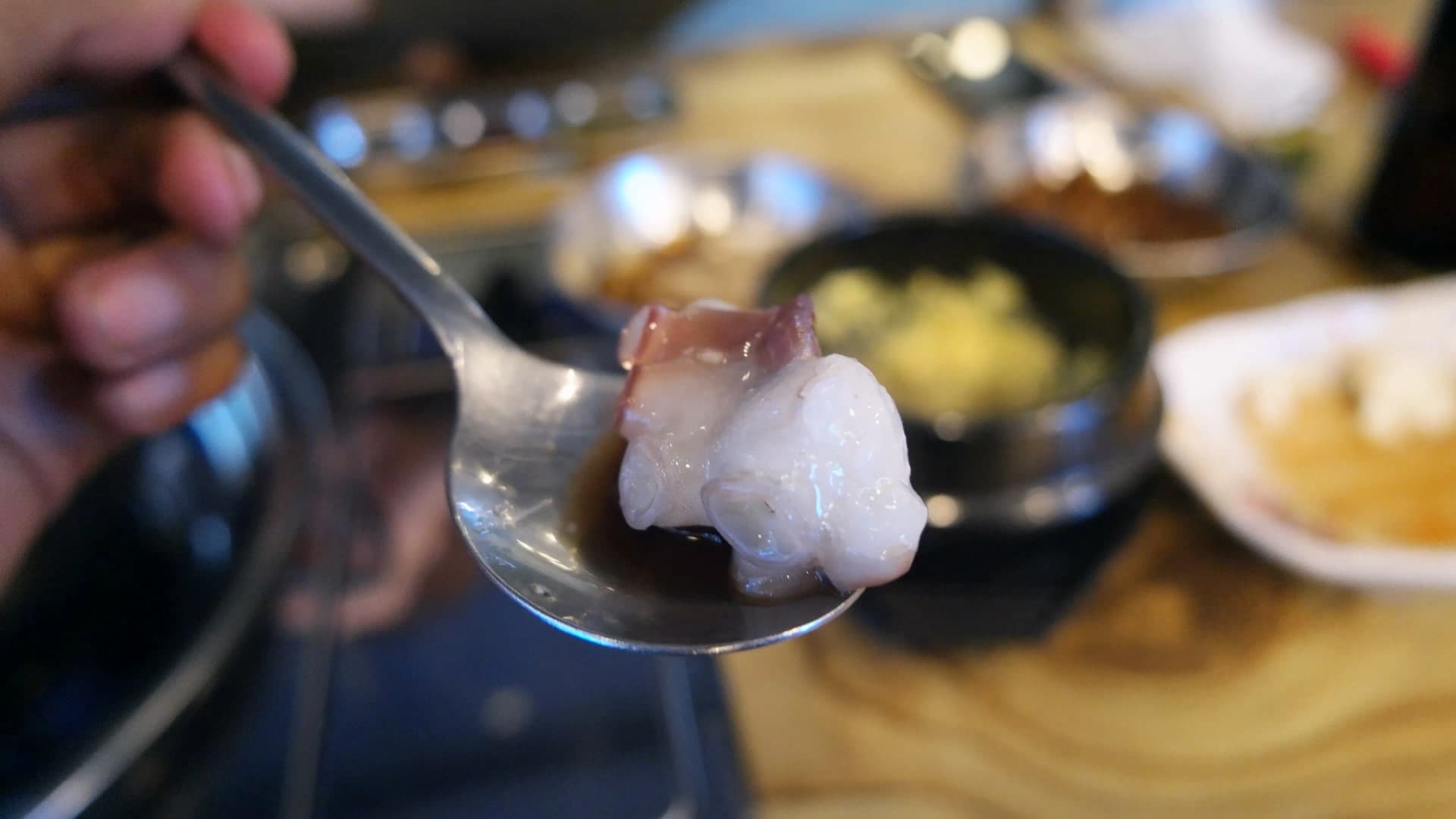 조개찜 문어살 숟가락 — 잘 익은 한국 생문어살을 숟가락에 올린 모습 | 하이제이에스비