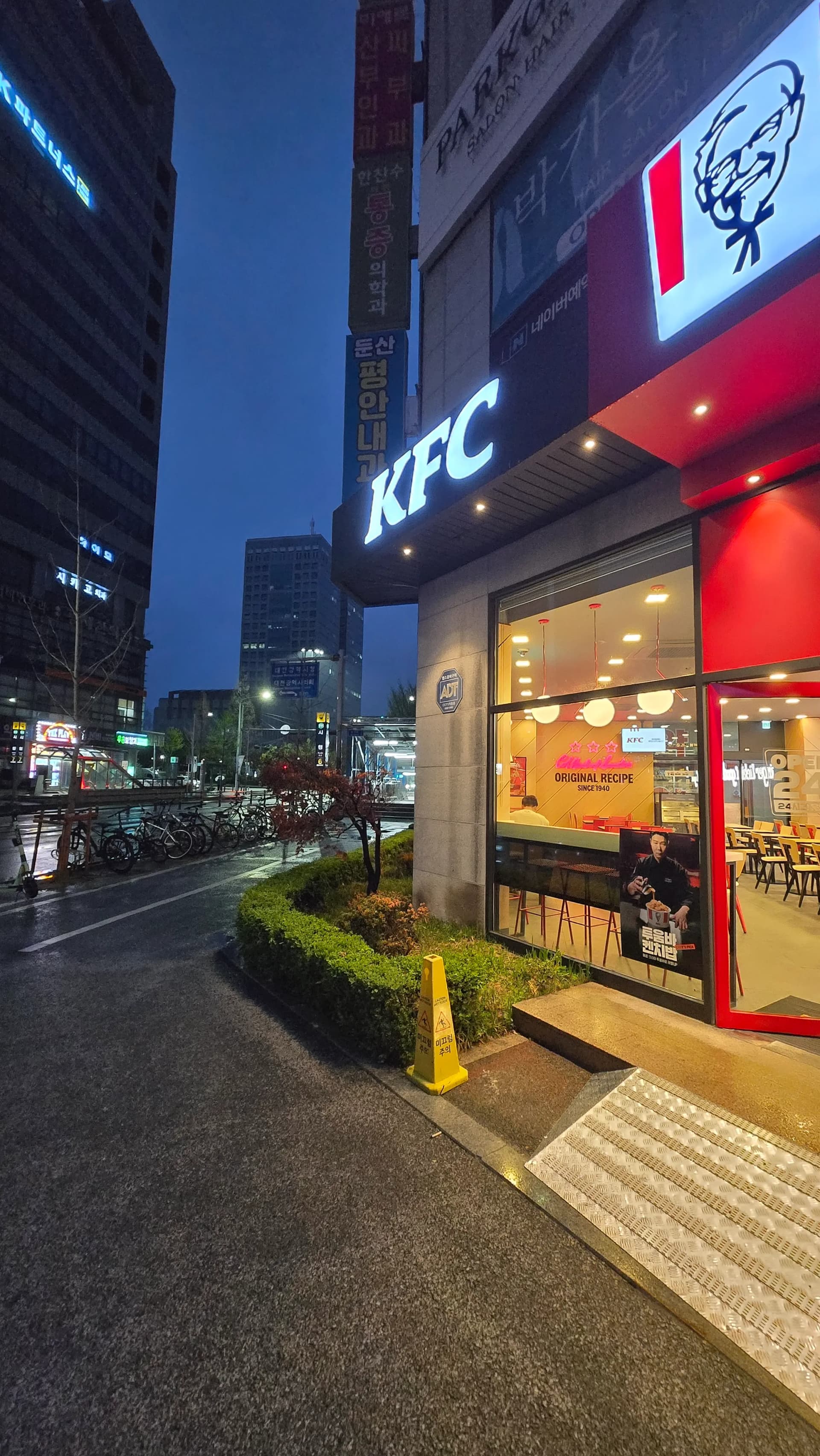 새벽 어두운 도로에서 간판 불빛만 환하게 켜져 있는 한국 24시간 KFC 매장 외관