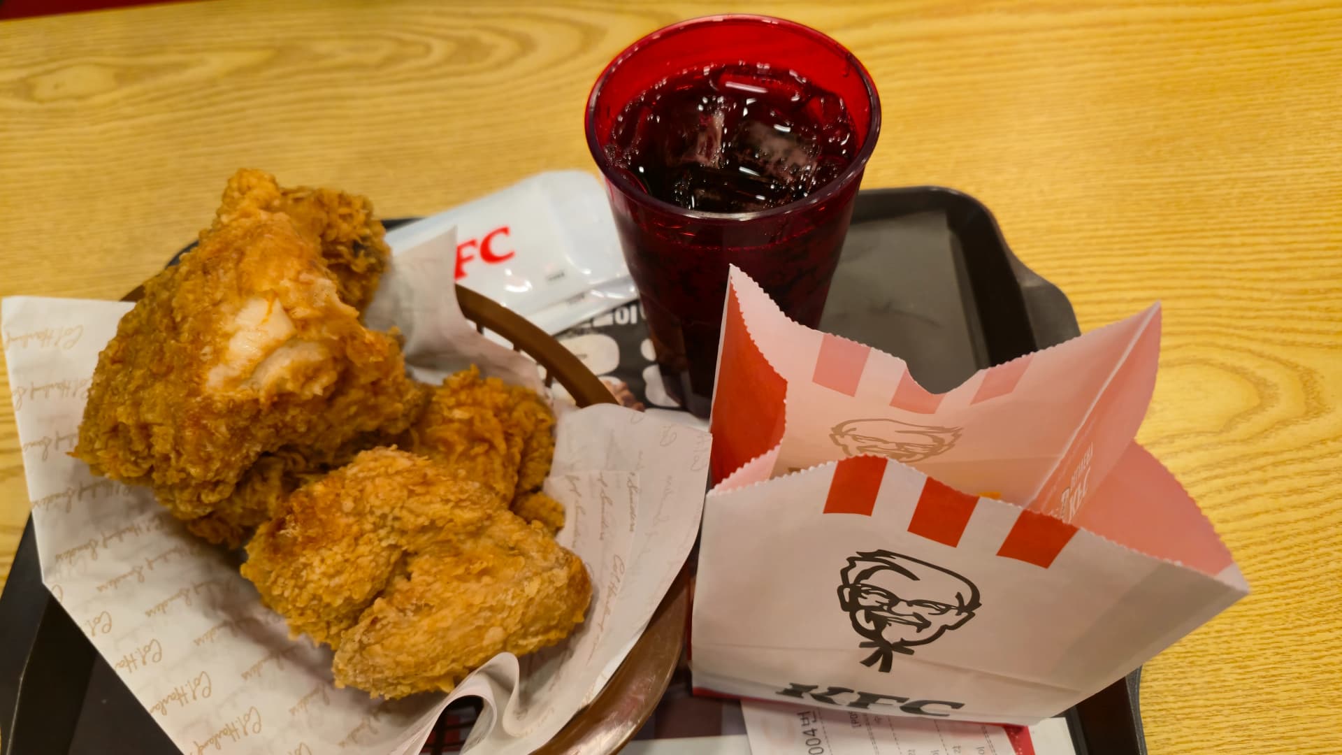 한국 KFC 치킨 콜라 감자튀김이 빨간 트레이 위에 놓인 테이블 전경