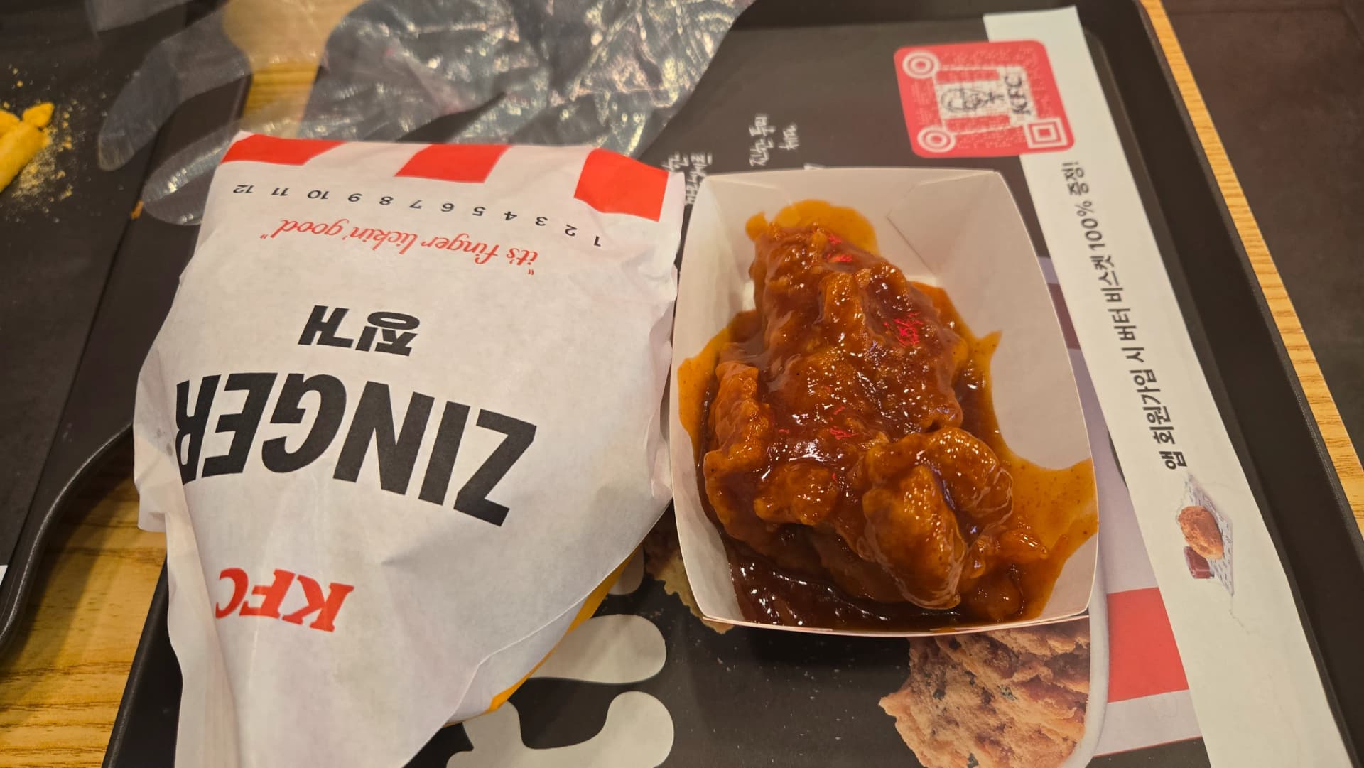 한국 KFC 갓양념치킨 순살 박스를 열었을 때 소스가 듬뿍 묻어 있는 모습과 비닐장갑