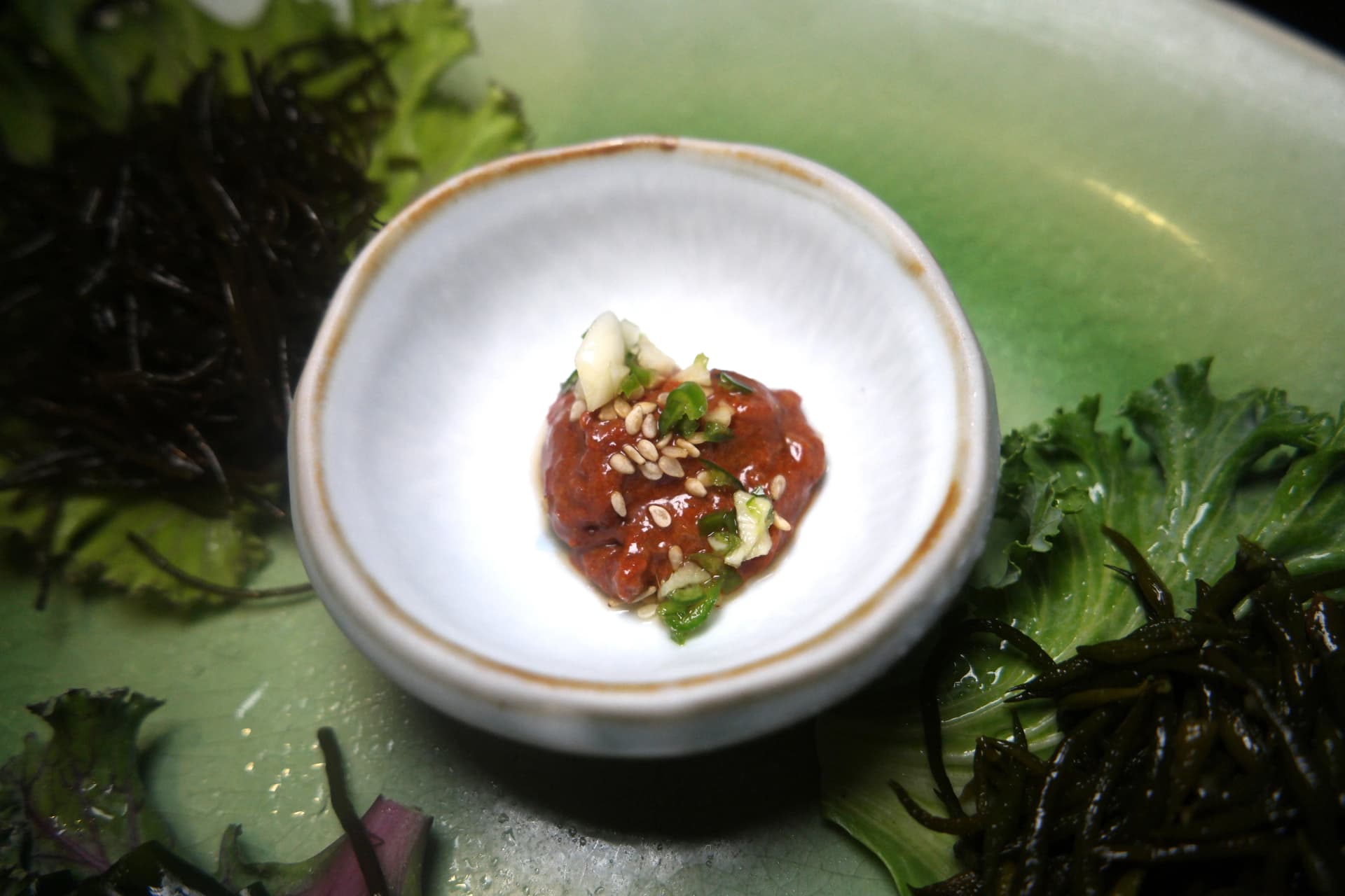 Primer plano de chojang, salsa coreana agridulce y picante con semillas de sésamo y cebolleta por encima | 하이제이에스비