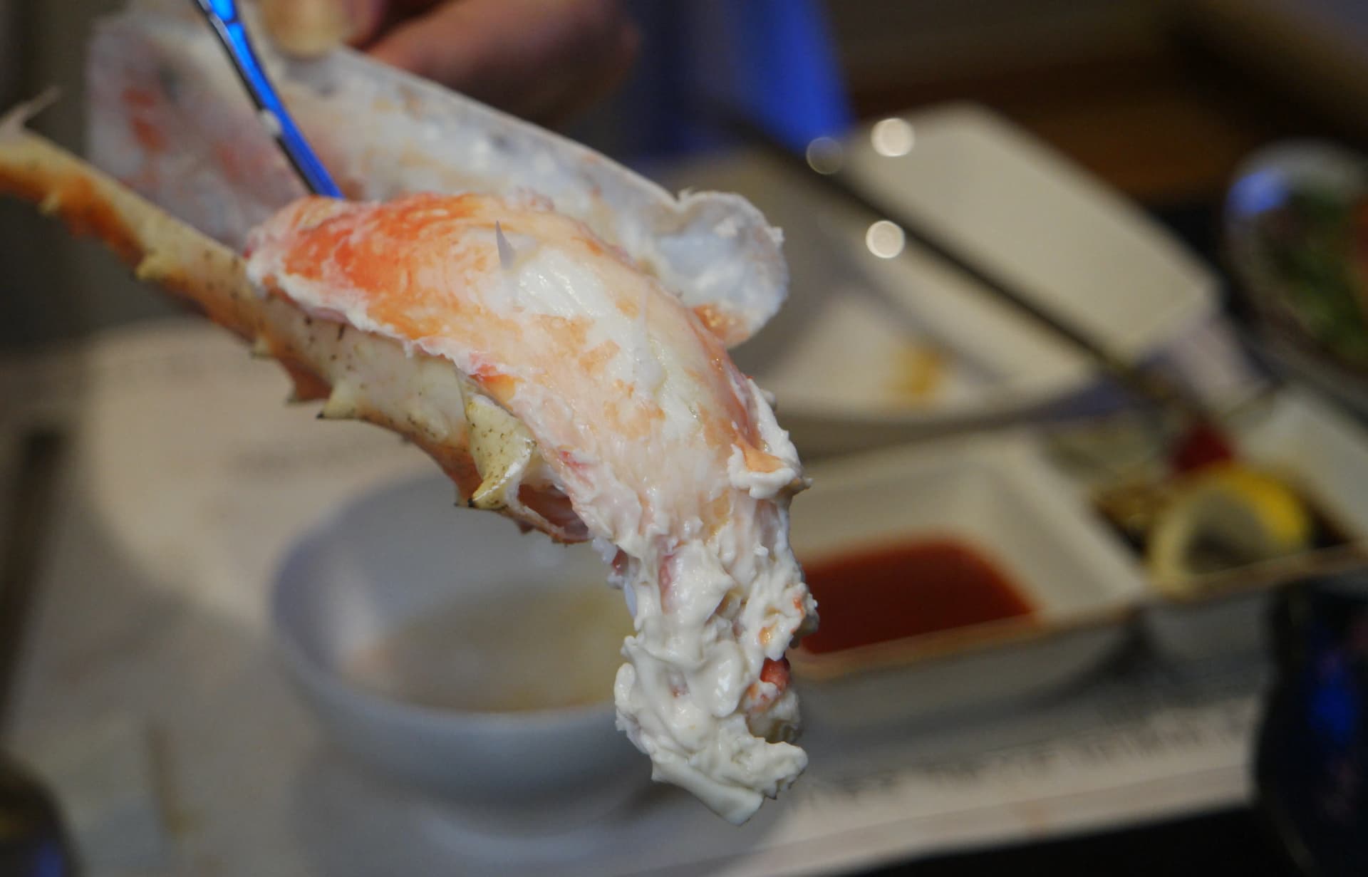 Caparazón de pata de cangrejo real abierto revelando carne blanca, firme y jugosa en su interior | 하이제이에스비