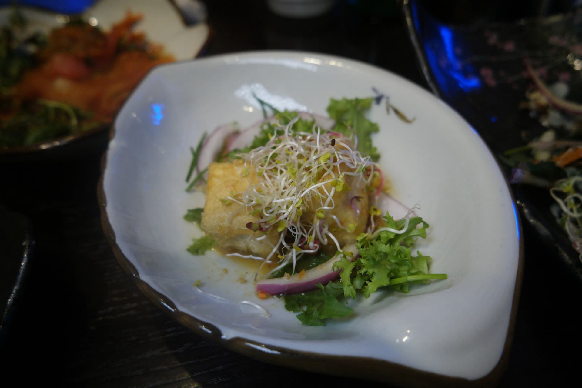 Ensalada de tofu frito crujiente cubierto con brotes tiernos y cebolla | 하이제이에스비