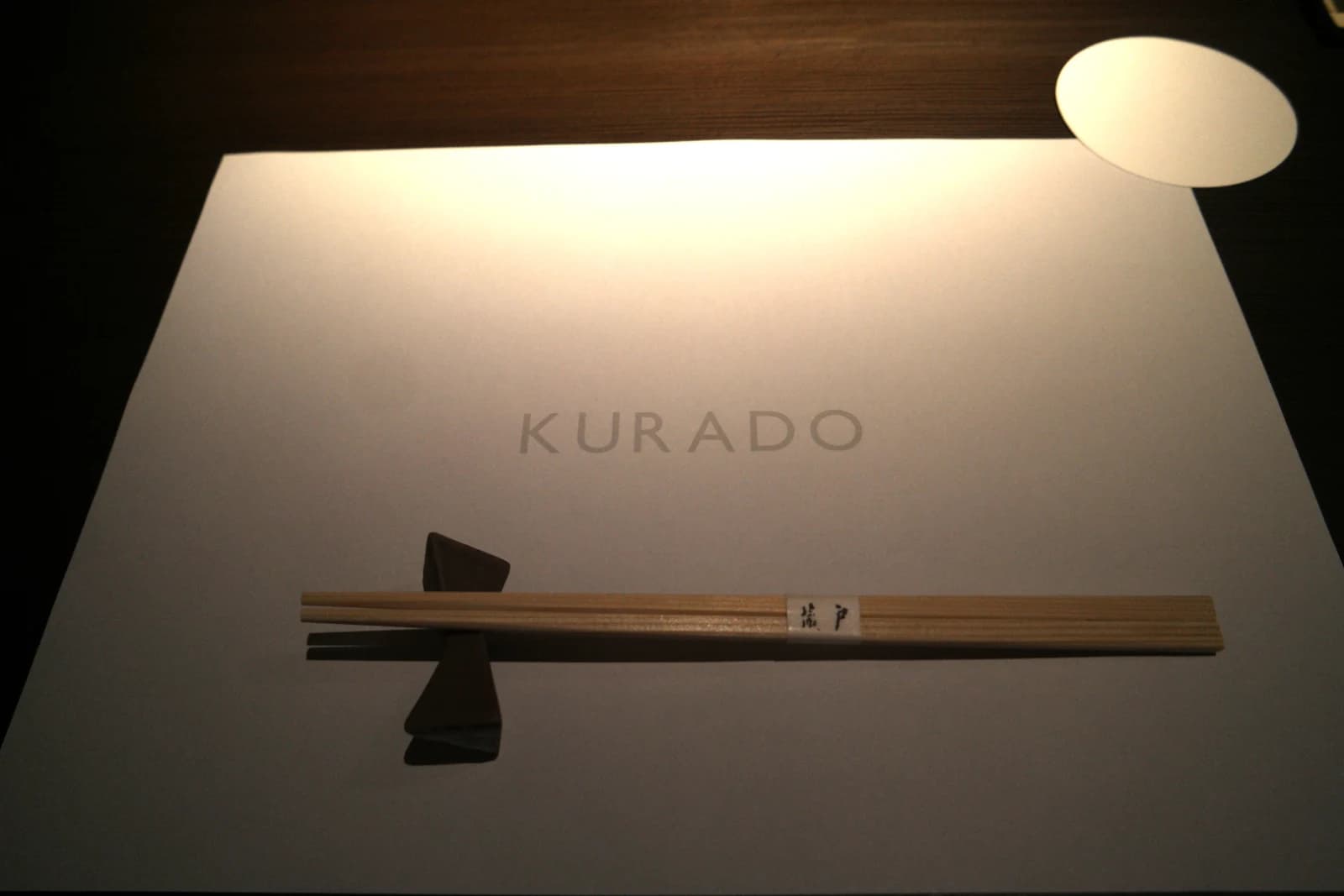 Gros plan sur les baguettes en bois gravées au nom du restaurant Kurado