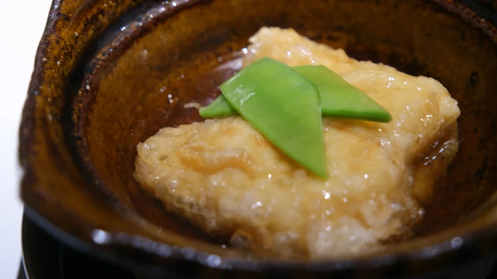 Gros plan sur l'agedashi-dofu, surface dorée et croustillante du tofu frit