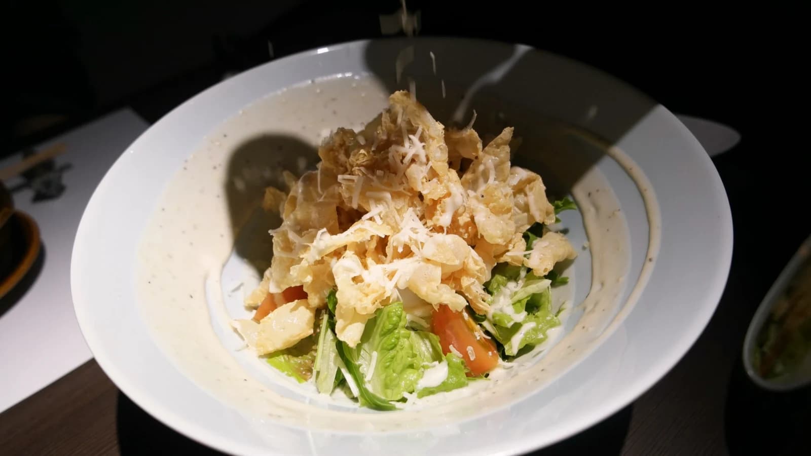 Salade de Kurado avec laitue et tomates fraîches sur grande assiette blanche