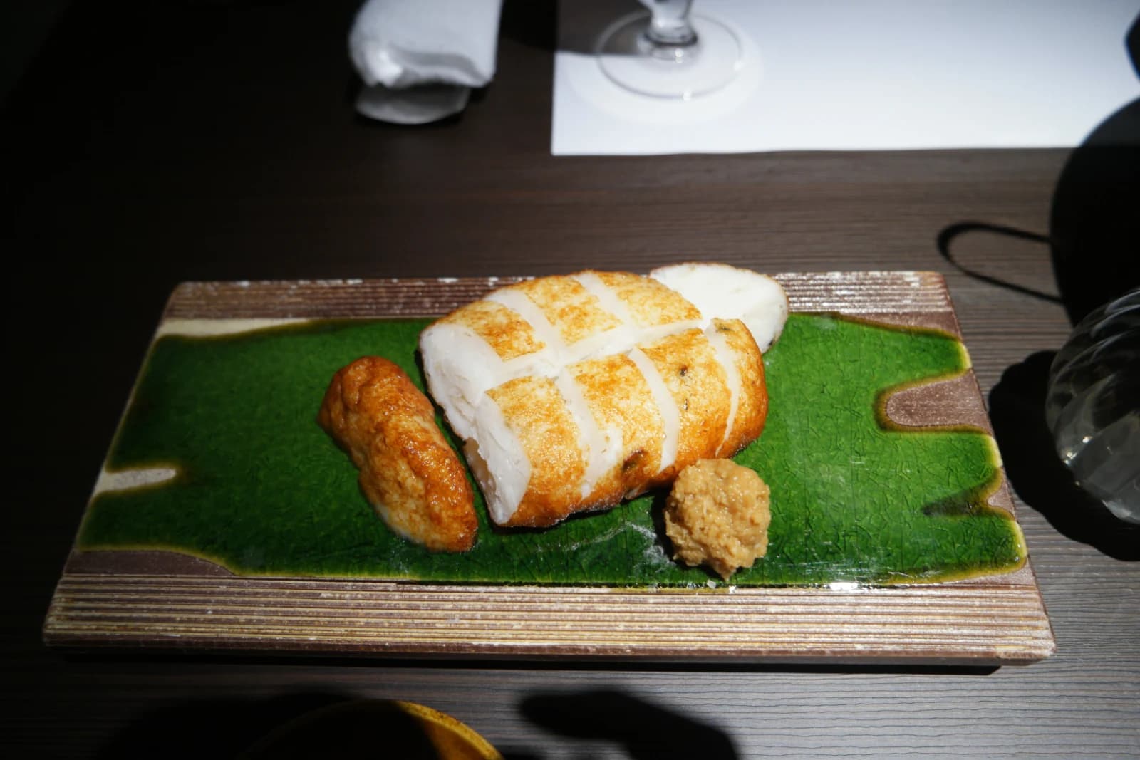 Vue d'ensemble de la table de Kurado avec plusieurs assiettes du menu omakase