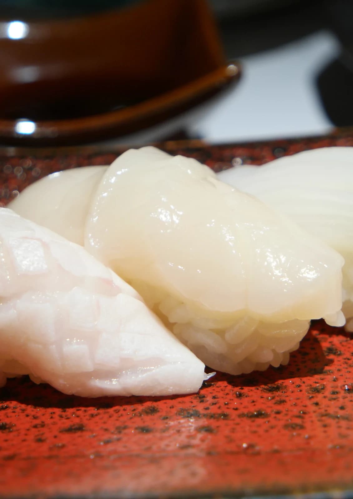 Sushi de Saint-Jacques translucide à la surface lisse et brillante, calé sur le riz