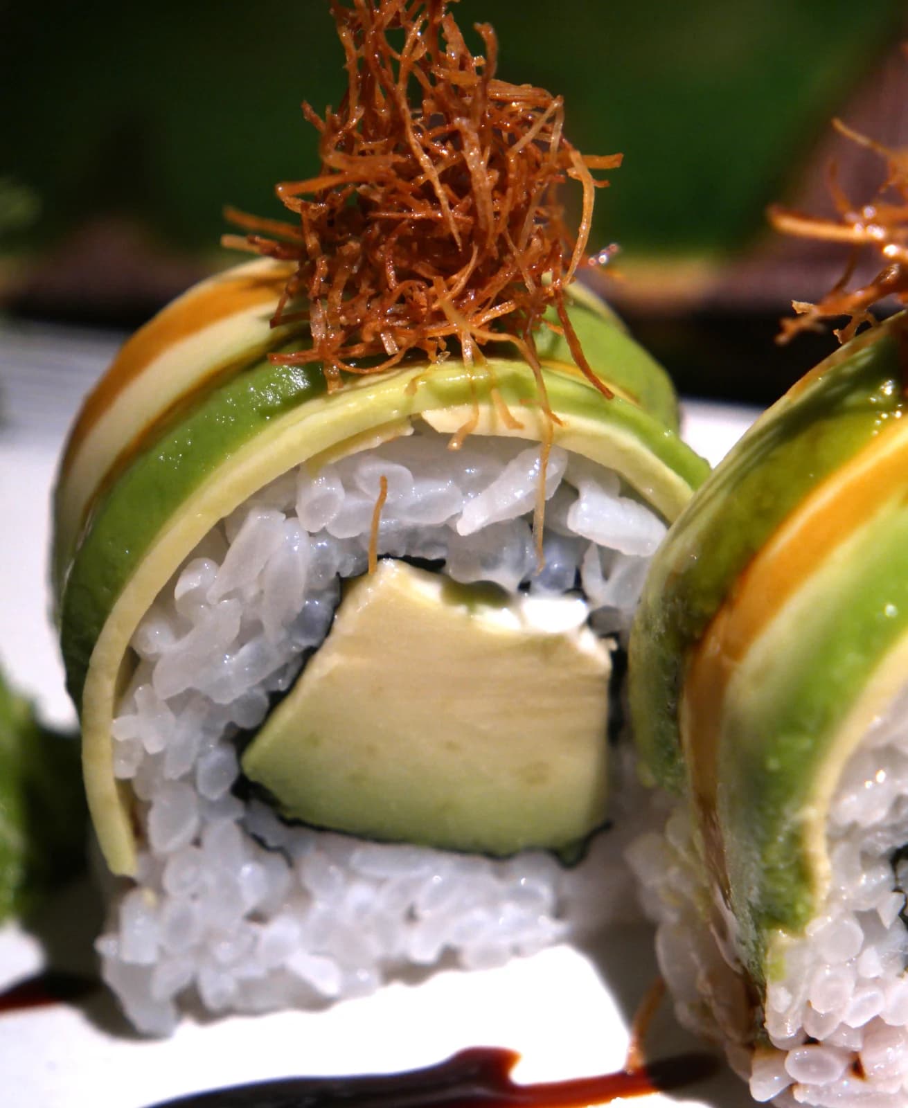 Maki à l'avocat vu de près, fines tranches superposées comme des pétales fins