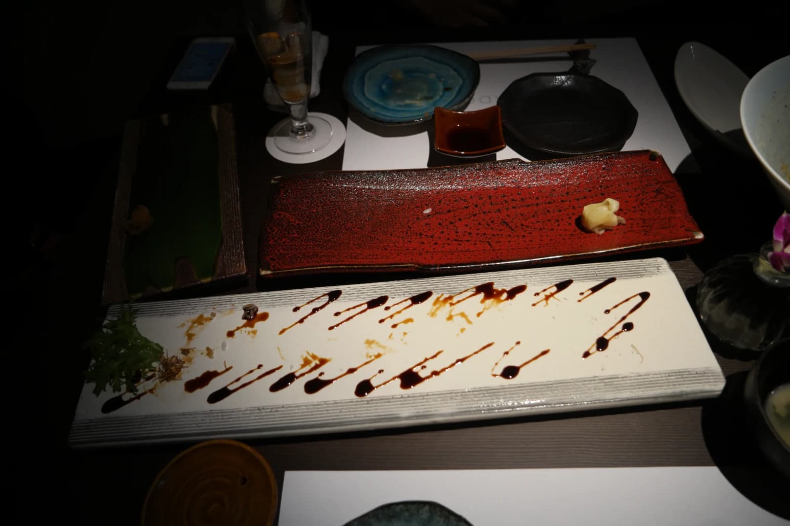 Assiettes vides chez Kurado après le repas, gari restant sur l'assiette rouge et sauce dessinée sur l'assiette blanche