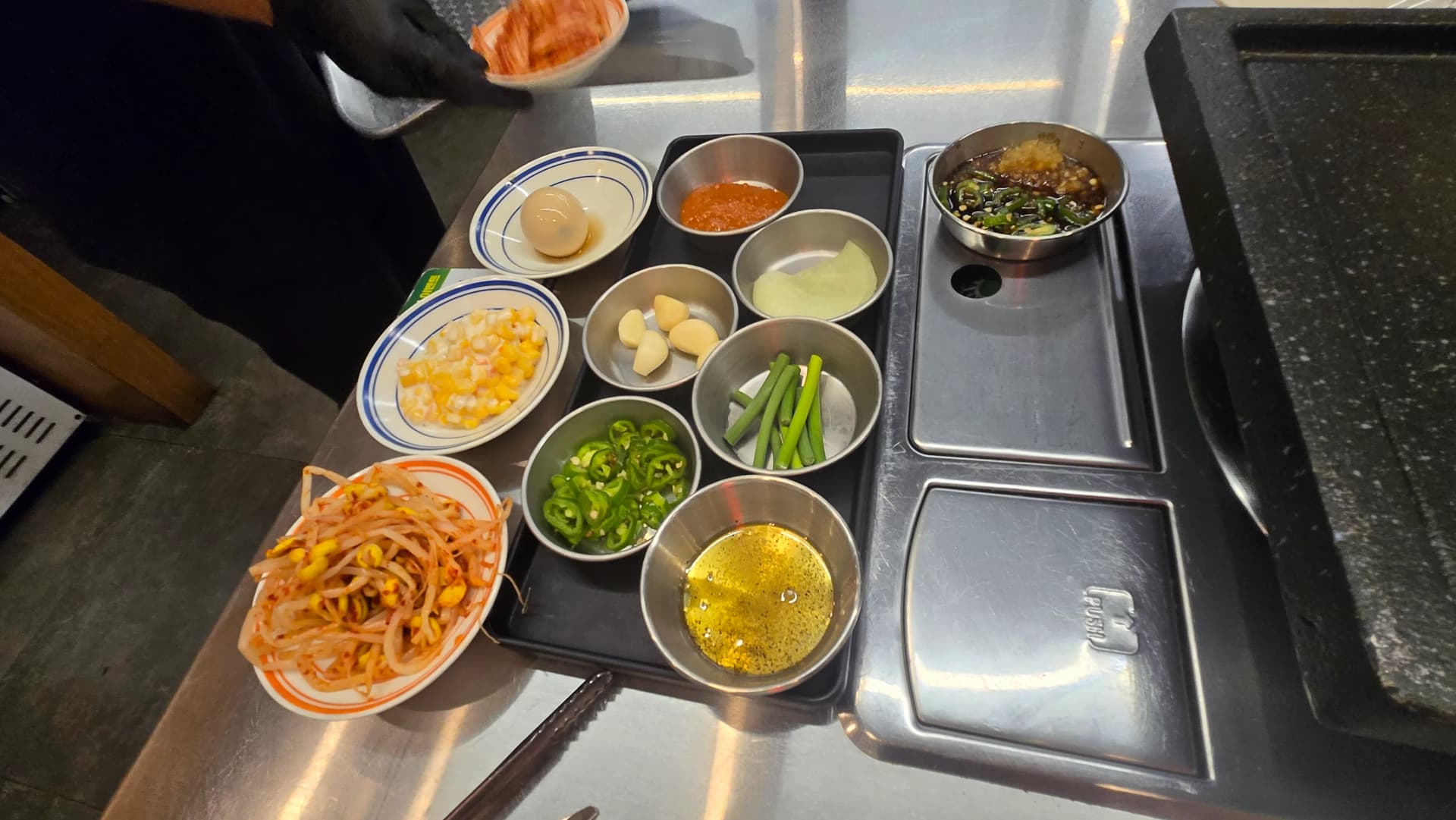 Маса в корейски ресторант за макчан на скара с основни гарнитури | 하이제이에스비