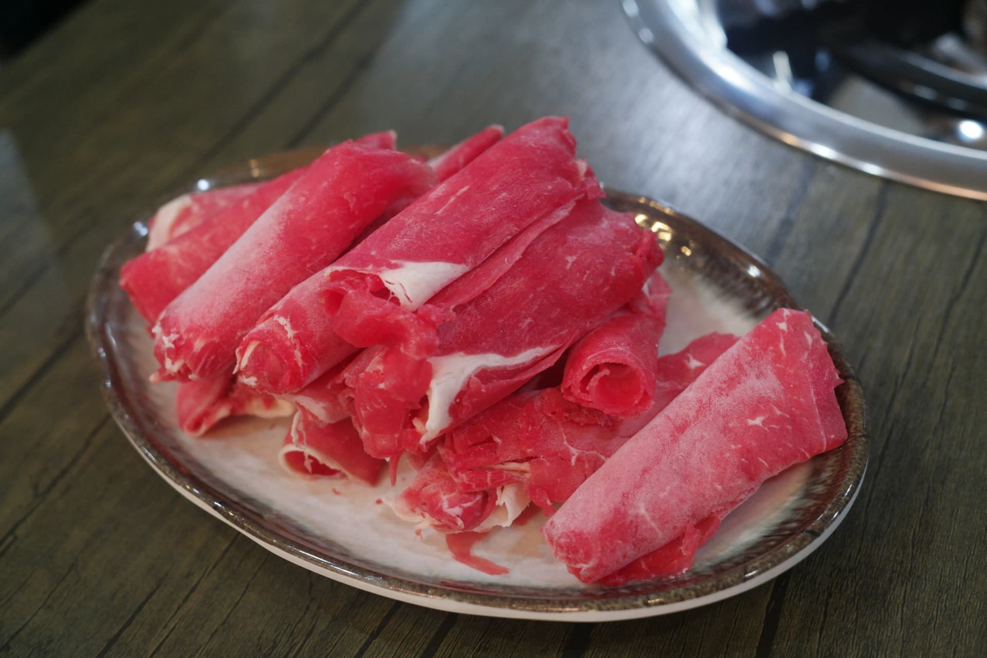 얇게 썬 소고기 샤브샤브용 고기가 접시에 담겨 있는 모습 | 하이제이에스비