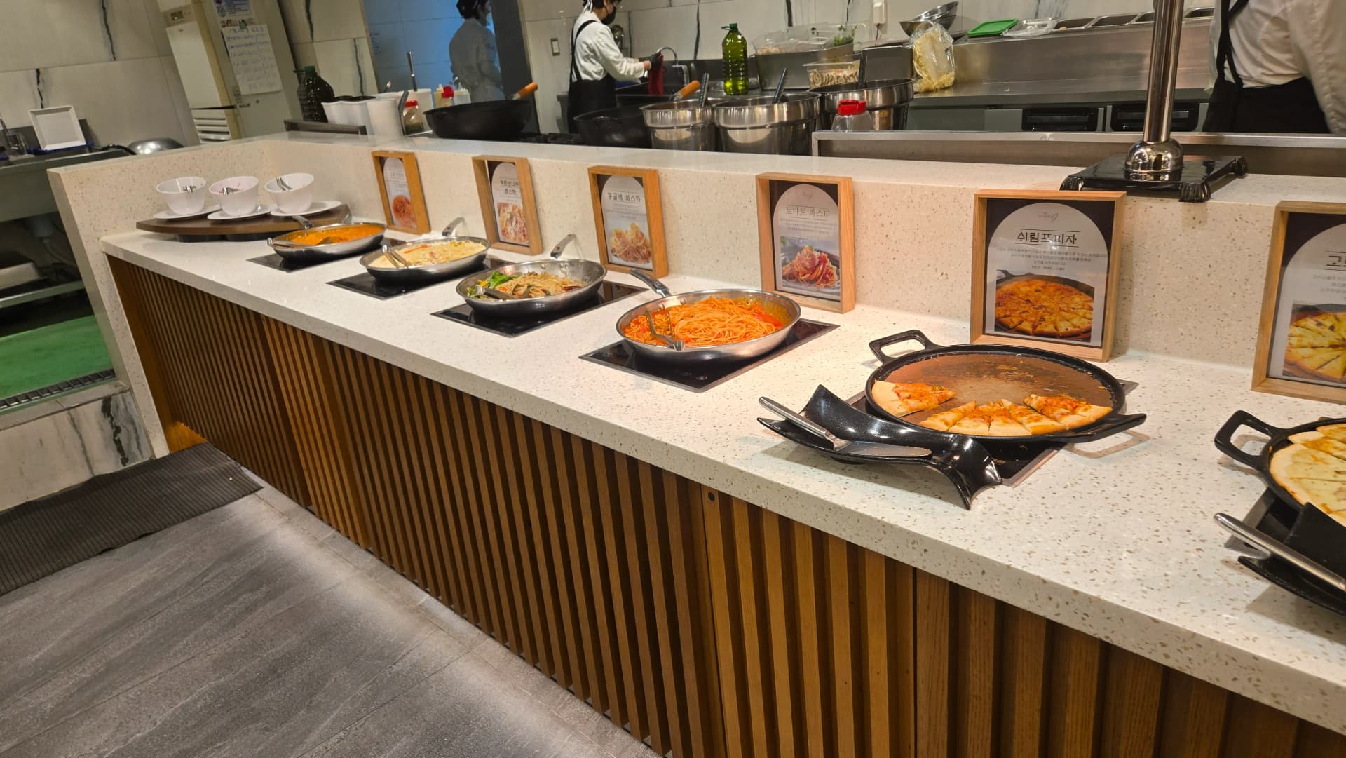 Mwonekano mzima wa sehemu ya vyakula vya Magharibi, pizza, pasta na vyakula vilivyokaangwa mbele ya jiko wazi | 하이제이에스비