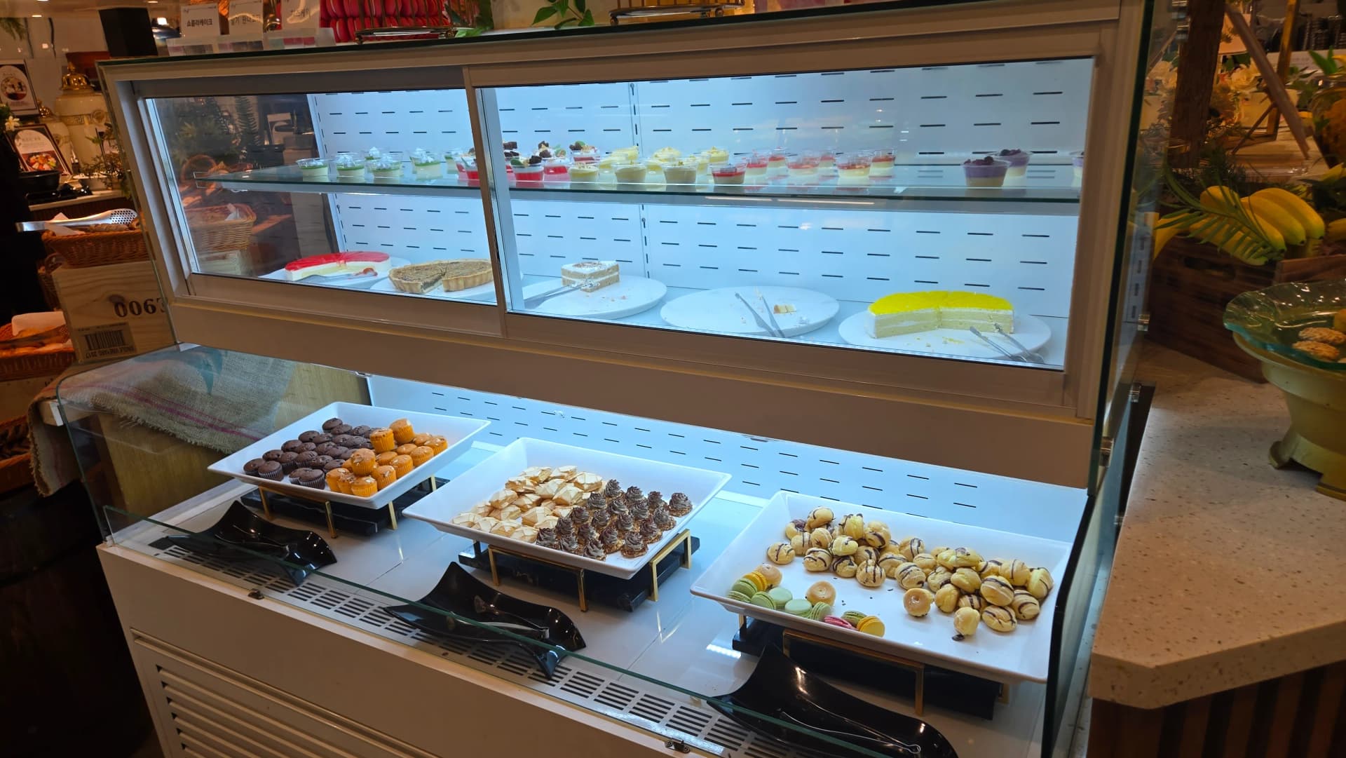 Kioo cha dessert za Magharibi, cupcakes, mousse, mpira wa chokoleti, macarons, cream puff na keki ndani ya kioo cha baridi | 하이제이에스비