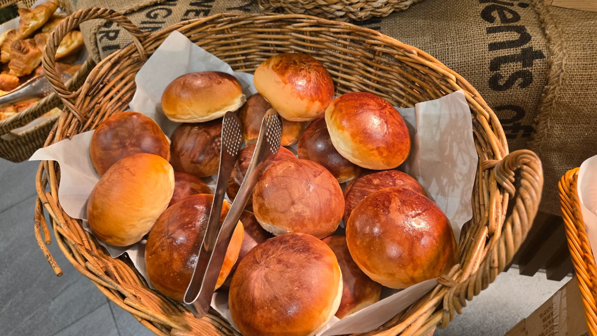 Mikate ya asubuhi ya Korea, mikate ya mviringo yenye kung'aa ya kahawia ndani ya kikapu, kama brioche rolls | 하이제이에스비