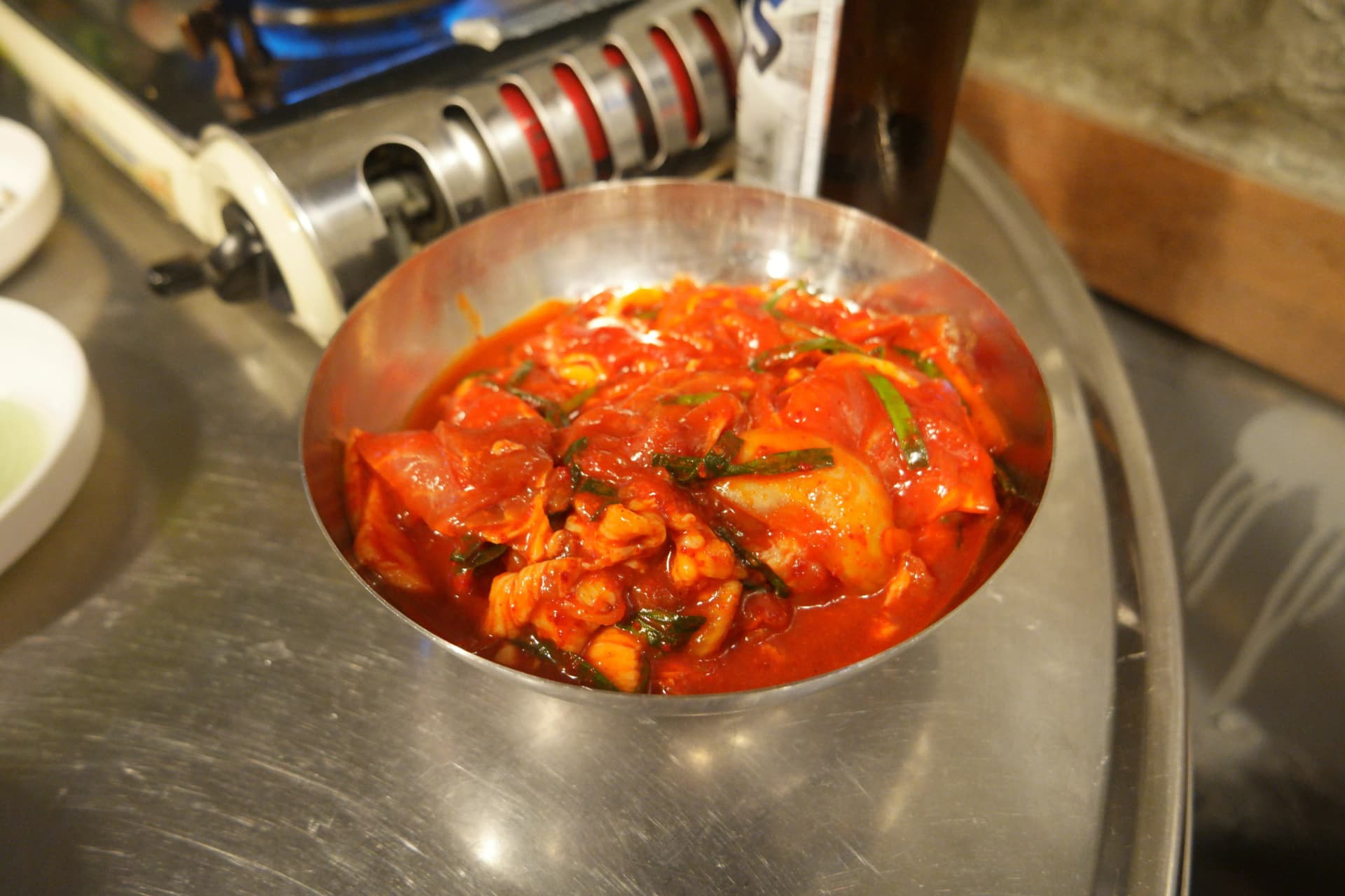 Jumulleok kali yenye mchuzi mwekundu wa gochujang ikifunika nyama ndani ya bakuli la chuma cha pua | 하이제이에스비