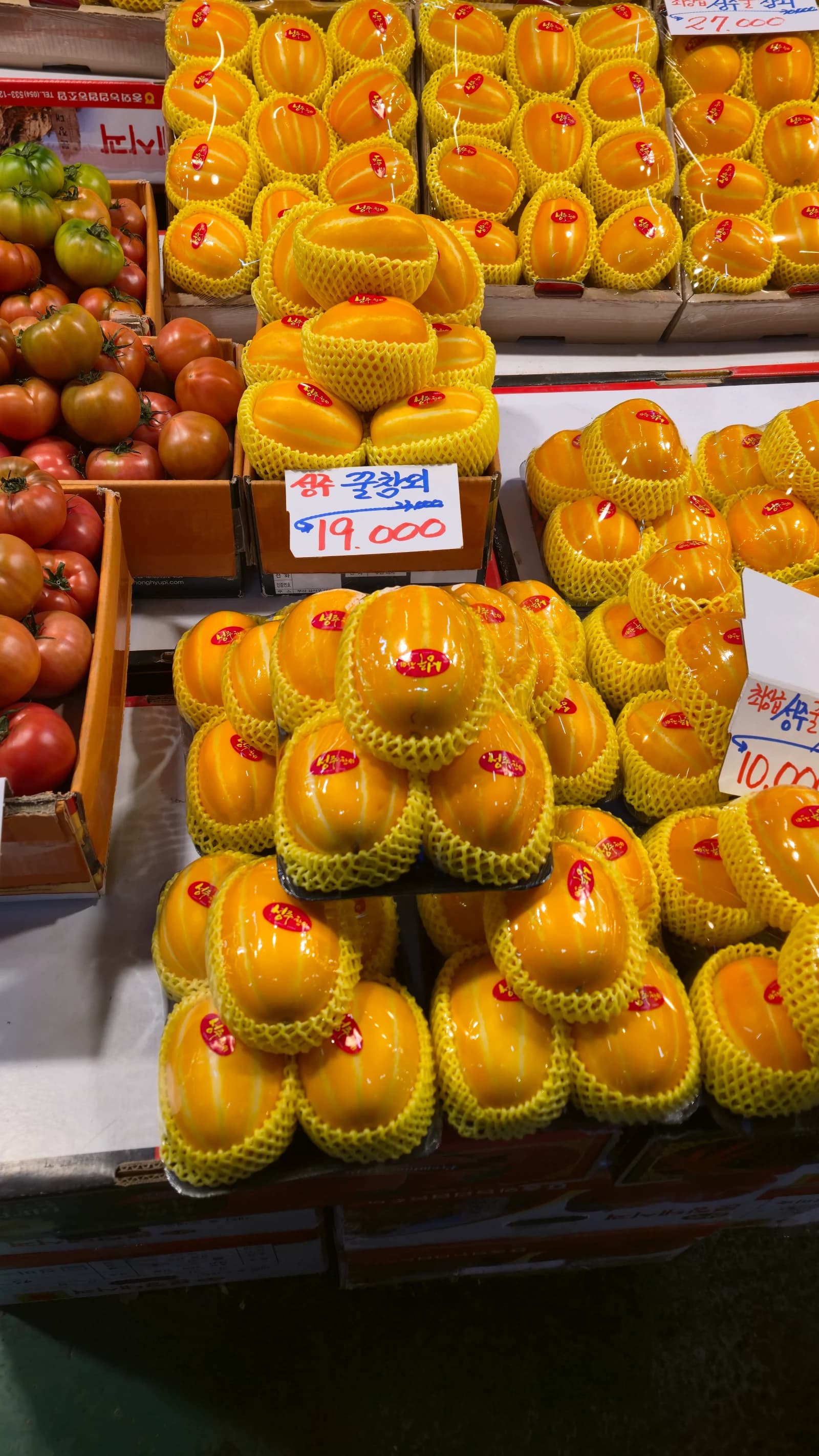 한국 전통시장 참외 진열대, 노란 참외가 봉지째 쌓여 있고 한 봉지 19000원 가격표가 보인다