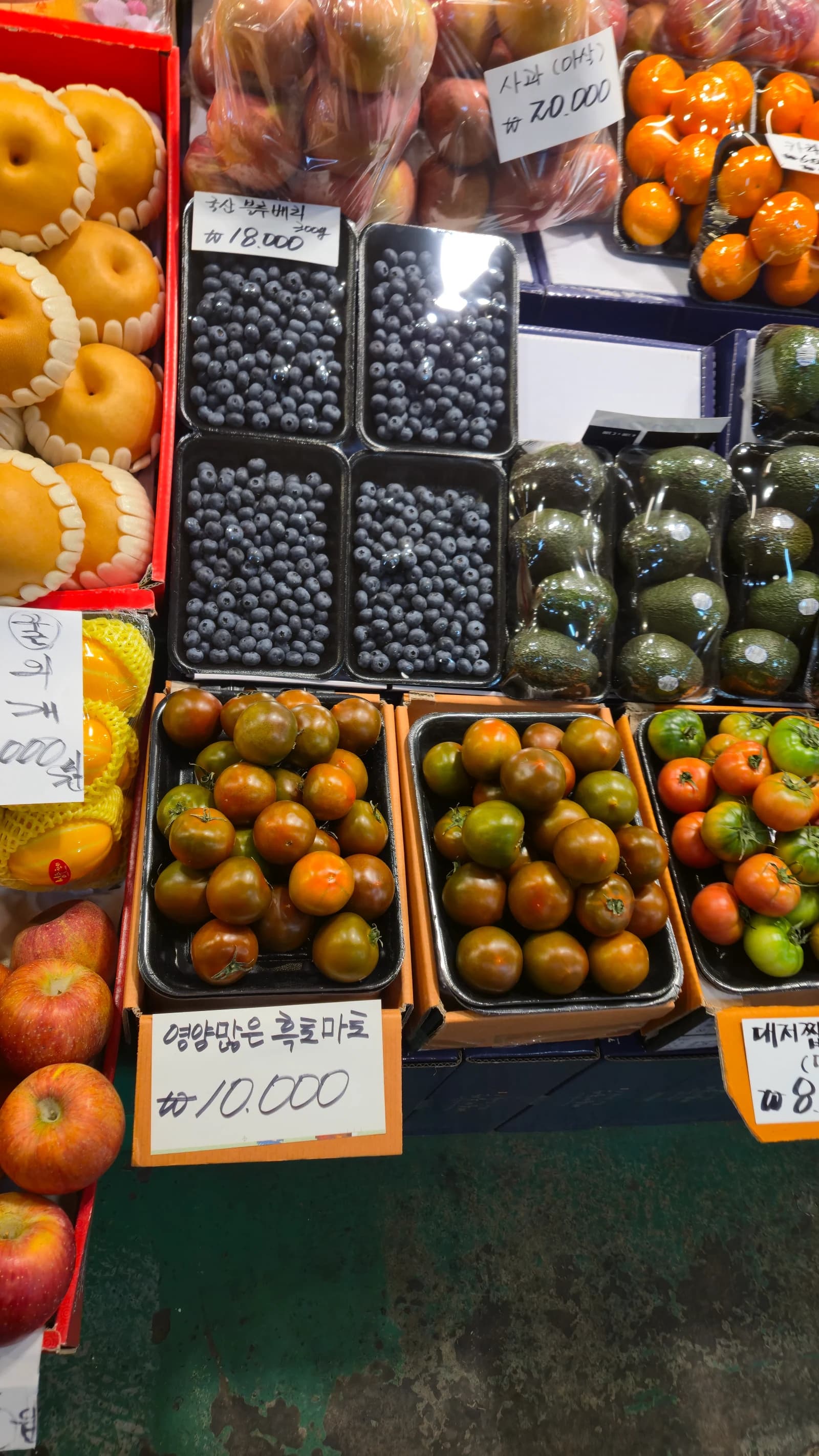 흑토마토 한 팩 10000원, 옆에 블루베리 아보카도 귤 배 사과가 함께 진열된 모습