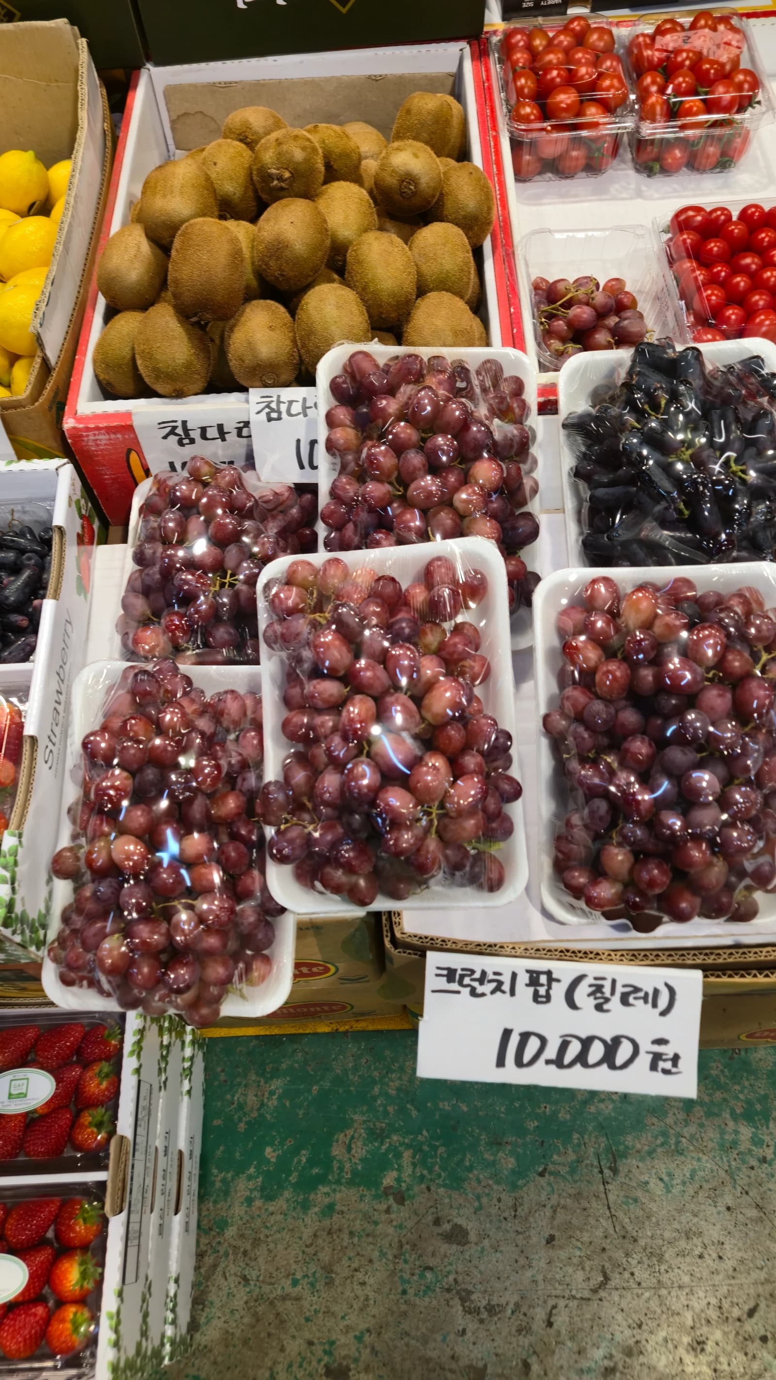 칠레산 크런치팜 포도 한 팩 10000원, 뒤로 키위 방울토마토 딸기 가지포도가 보인다