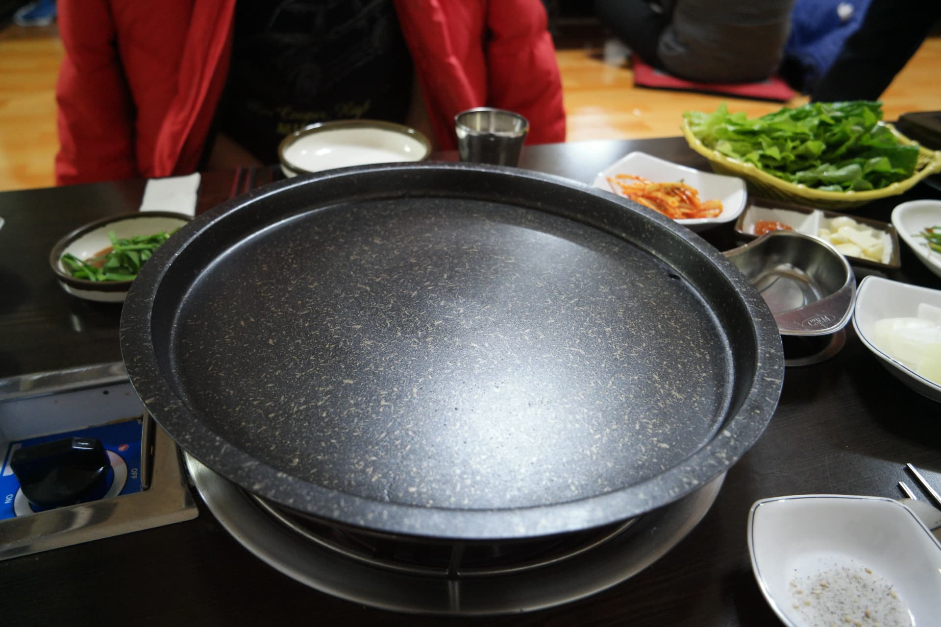 Restoran bebek panggang Korea dengan setup meja hot stone plate dan banchan | 하이제이에스비