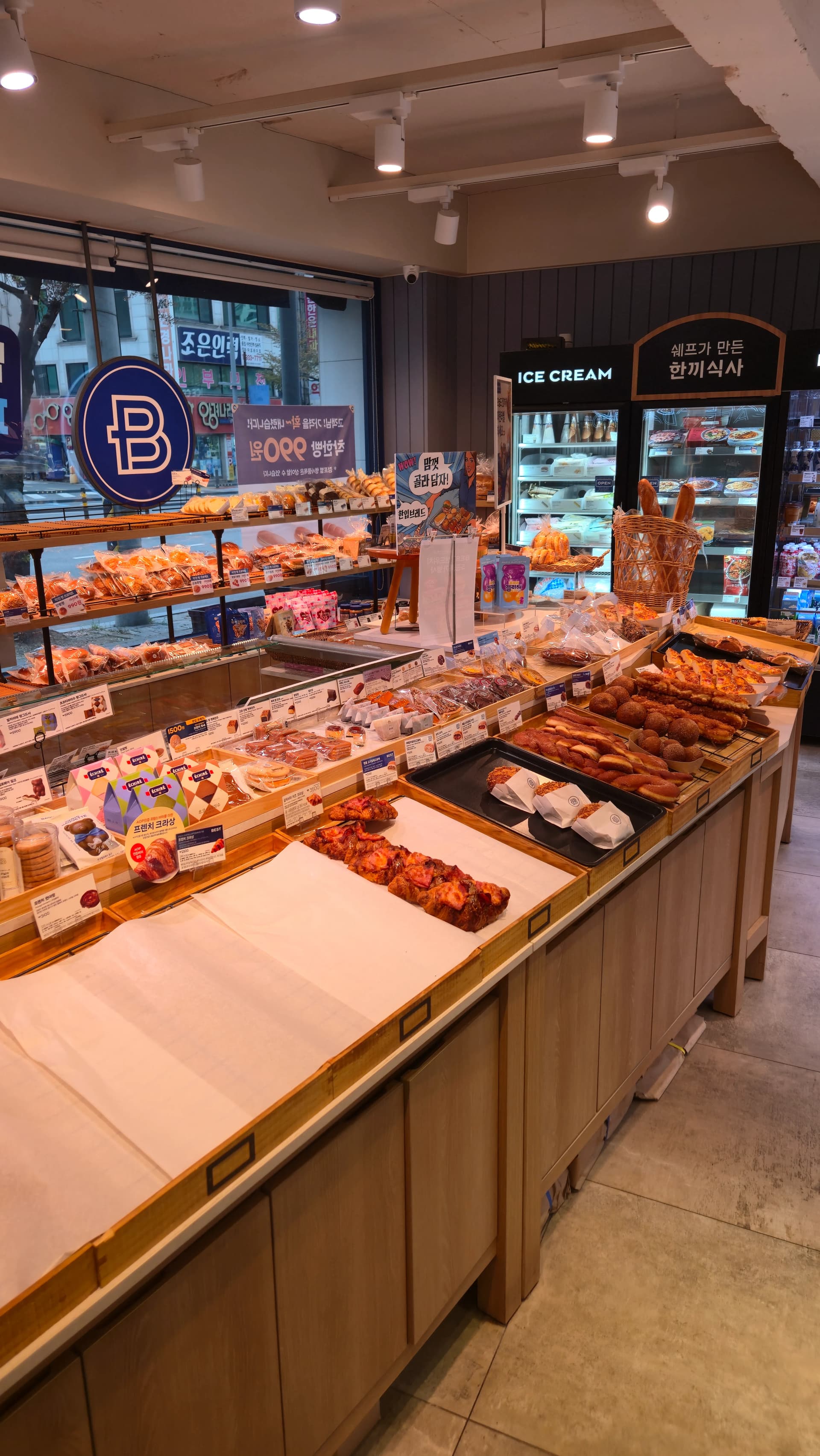 파리바게뜨 매장 내부 전경, 나무 진열대에 빵이 종류별로 놓여 있는 모습