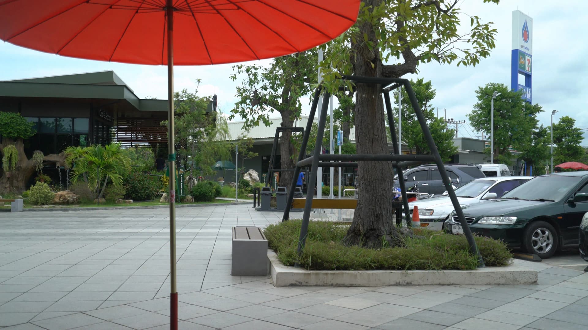 PTT petrol station complex in Rayong Thailand with red parasols 7-Eleven cafe and restaurant buildings