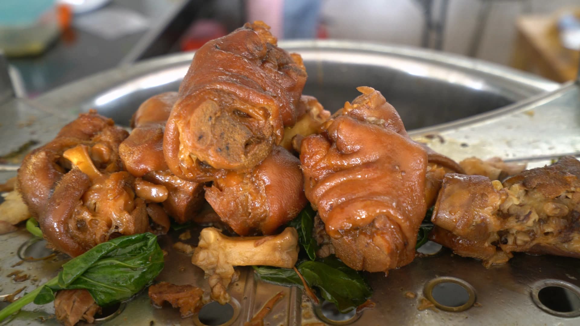 Close-up of braised pork leg for Thai rice dish showing gelatinous skin and tender pulled meat