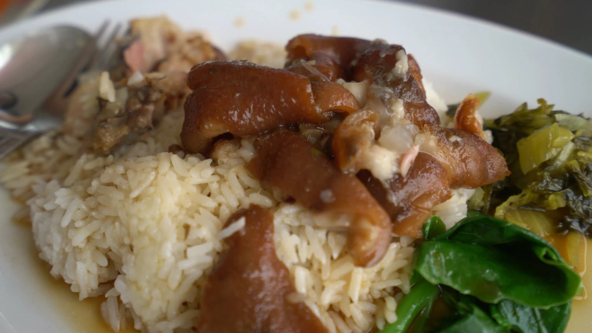 Khao kha moo close-up of gelatinous pork skin and silky tender shredded meat