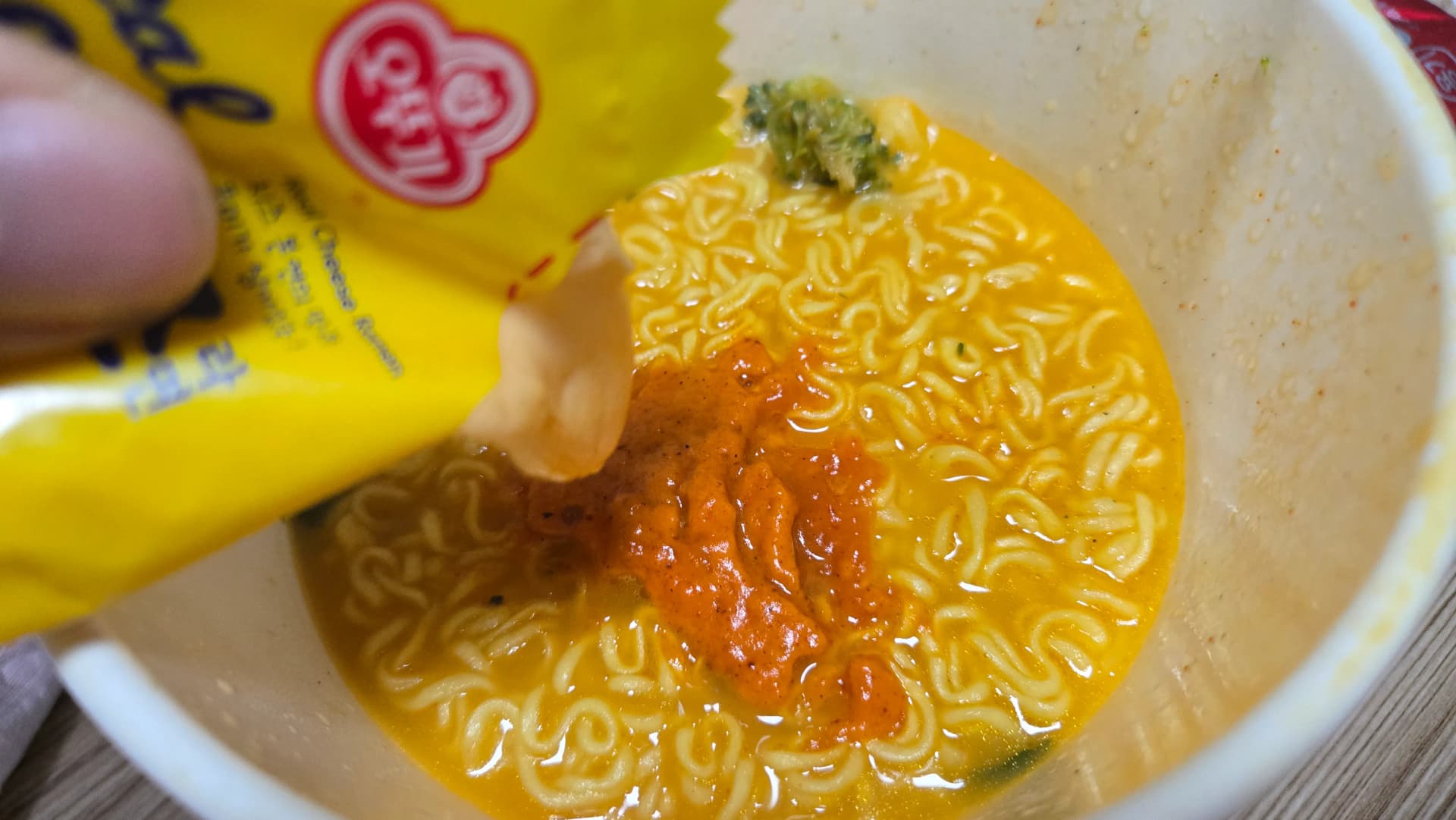 Afegint la salsa líquida Real Cheese del sobre groc a l’Ottogi Real Cheese Ramen | 하이제이에스비