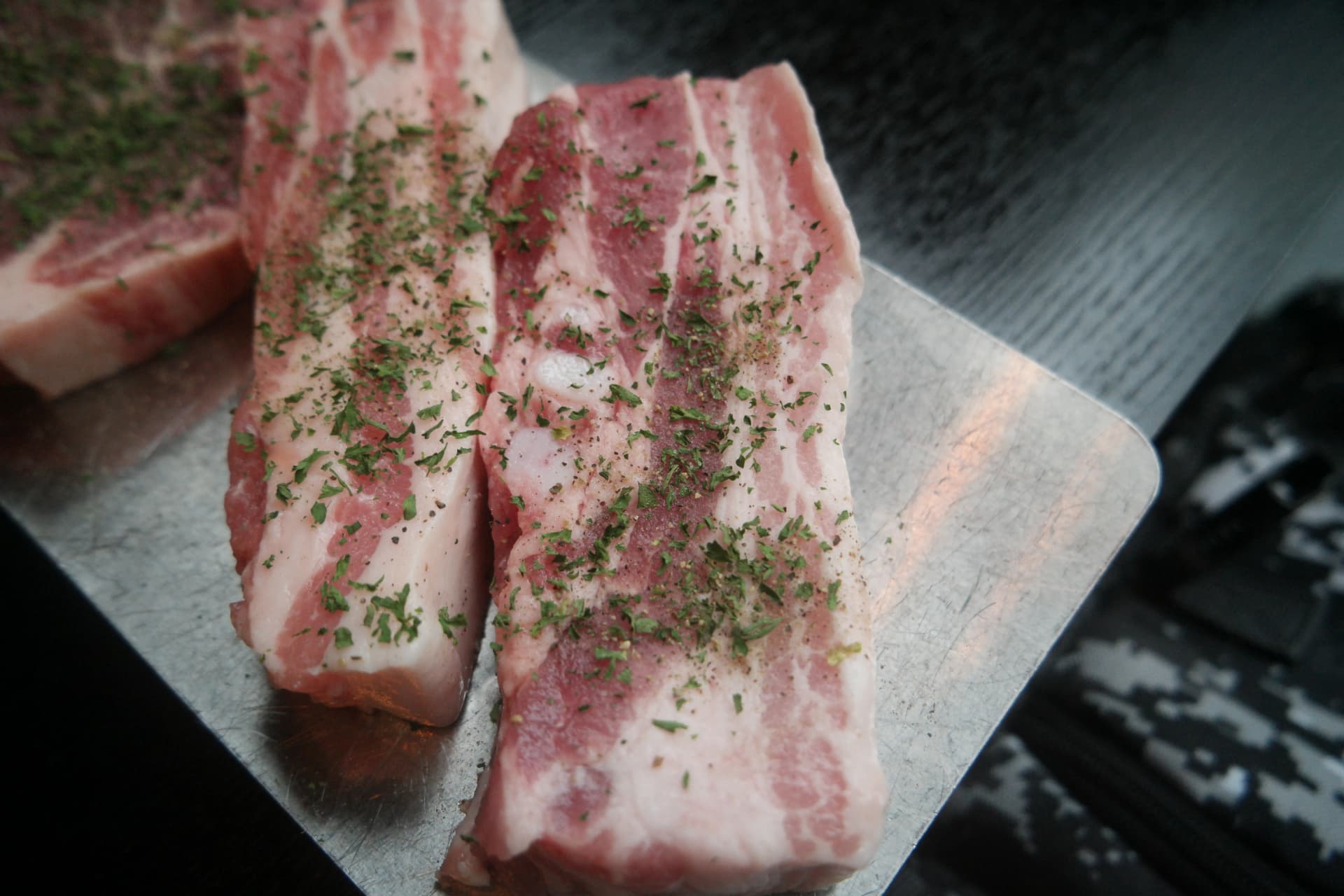 Primo piano della pancetta coreana cruda con strati alternati di grasso e carne ben visibili | 하이제이에스비