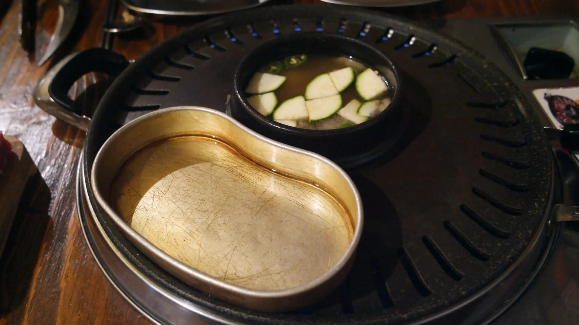 한국 삼겹살 전문점 테이블 기본 세팅 - 가운데 불판과 된장찌개, 반합이 놓인 모습 | 하이제이에스비