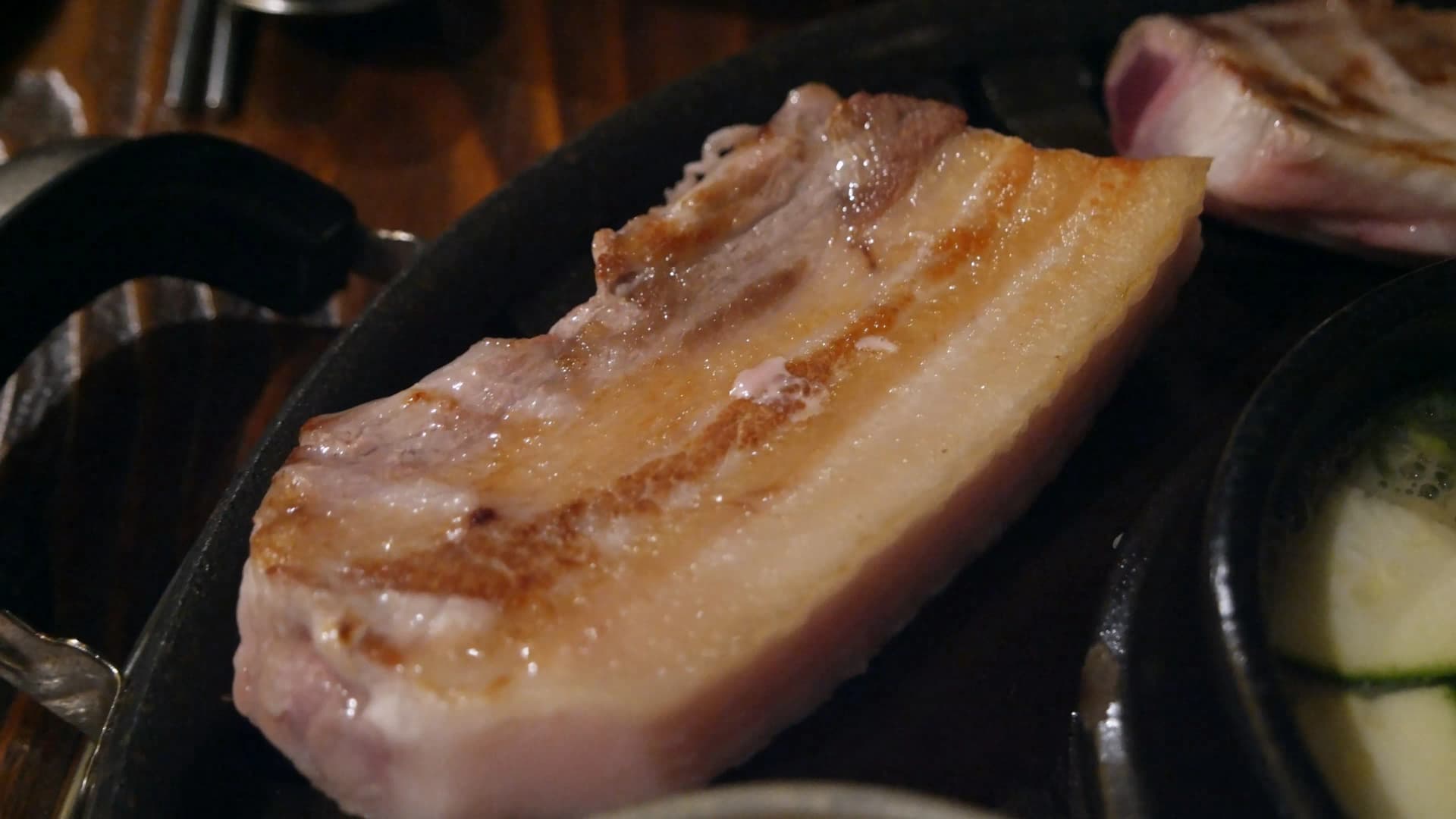 한 면이 노릇노릇하게 갈색으로 익은 삼겹살 클로즈업 | 하이제이에스비