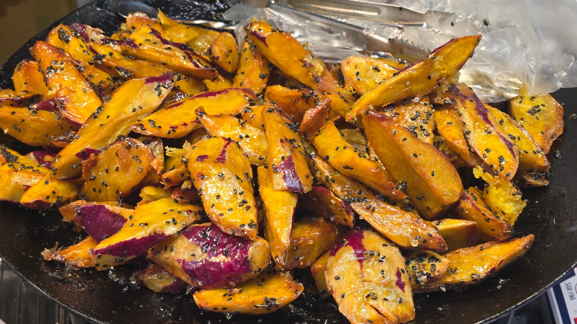 Kandierte Süßkartoffeln auf dem Seomun-Markt in Daegu — auf einer heißen Platte aufgetürmte, mit Zuckersirup glasierte Süßkartoffel-Stücke | 하이제이에스비