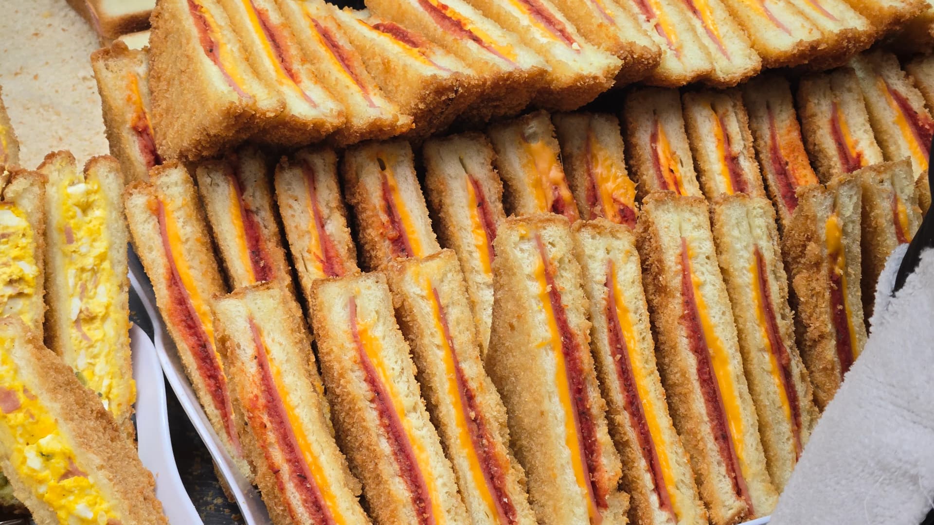 Querschnitt eines koreanischen Markt-Sandwiches — dicht gefüllt mit in Mayonnaise gebundenen Zutaten | 하이제이에스비