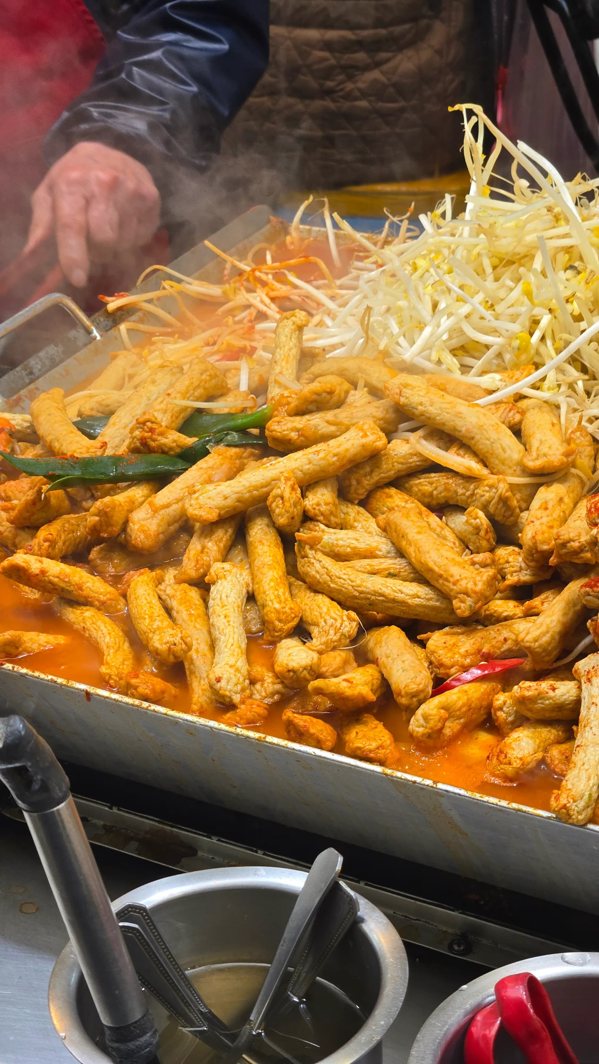 Rotes Fischkuchen-Pfannengericht auf dem Seomun-Markt — scharfes Eomuk-Gericht mit Sojasprossen und Chili | 하이제이에스비