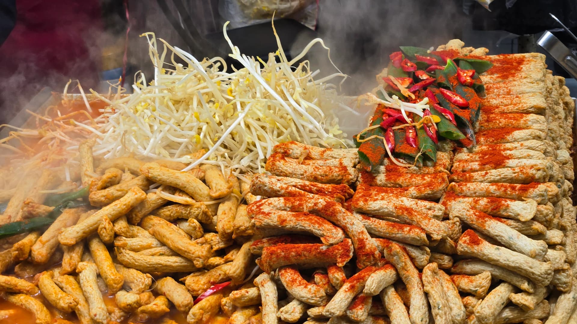 Nahaufnahme des scharfen Fischkuchen-Gerichts — kurz geschnittene Eomuk-Stücke brodelnd in Chilipulver-Gewürz | 하이제이에스비