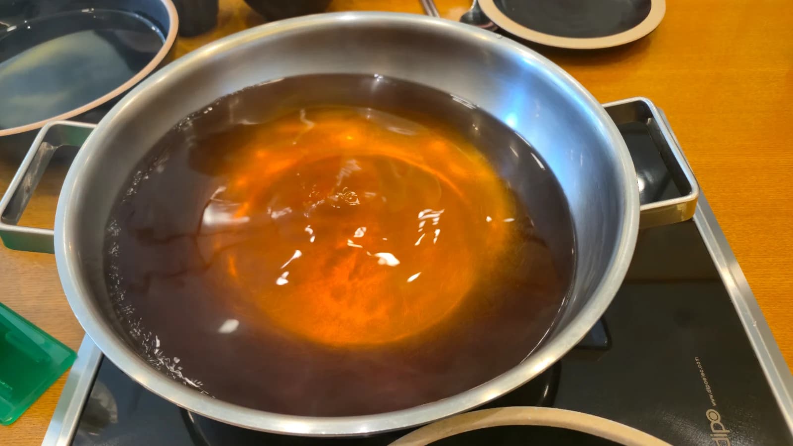 인덕션 위 냄비에 맑은 샤브샤브 육수가 끓고 있는 모습