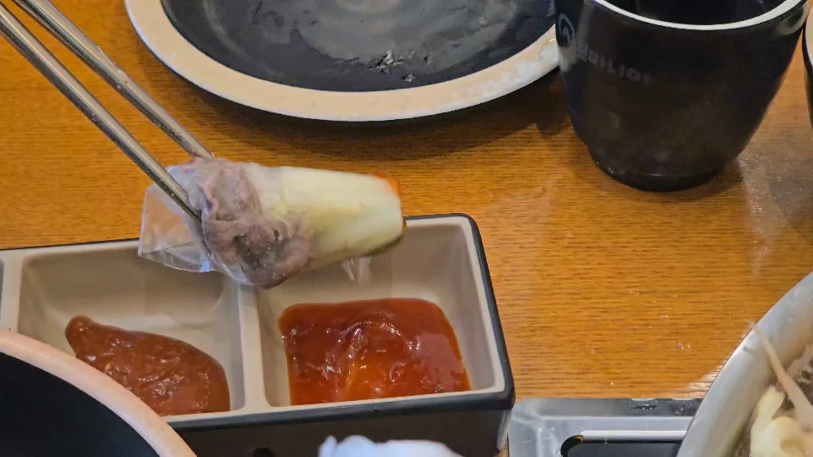 완성된 라이스페이퍼 월남쌈을 소스에 찍는 모습