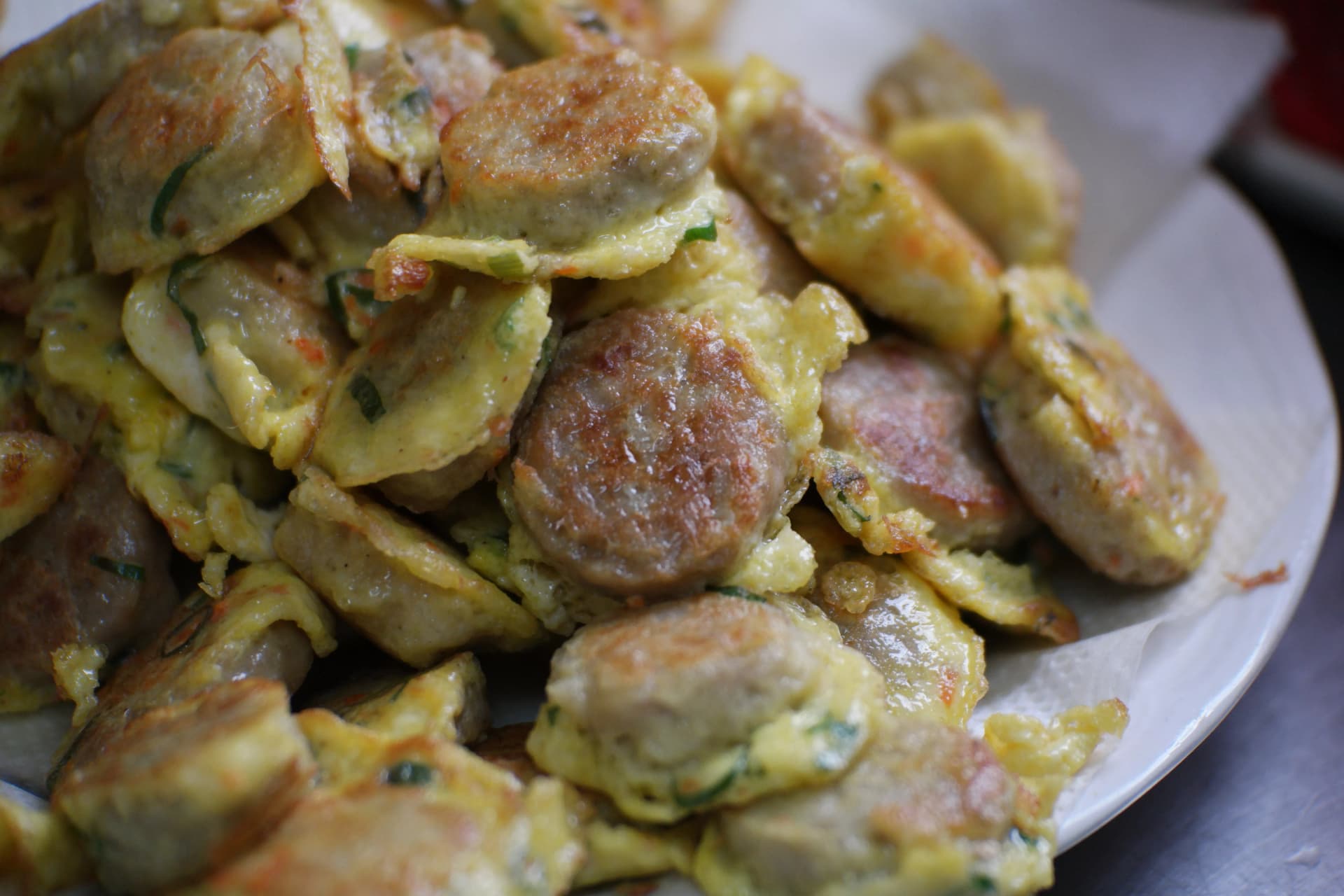 Close-up cross-section of donggeurangtteng showing the tofu and meat mixture inside with lumpy egg batter coating
