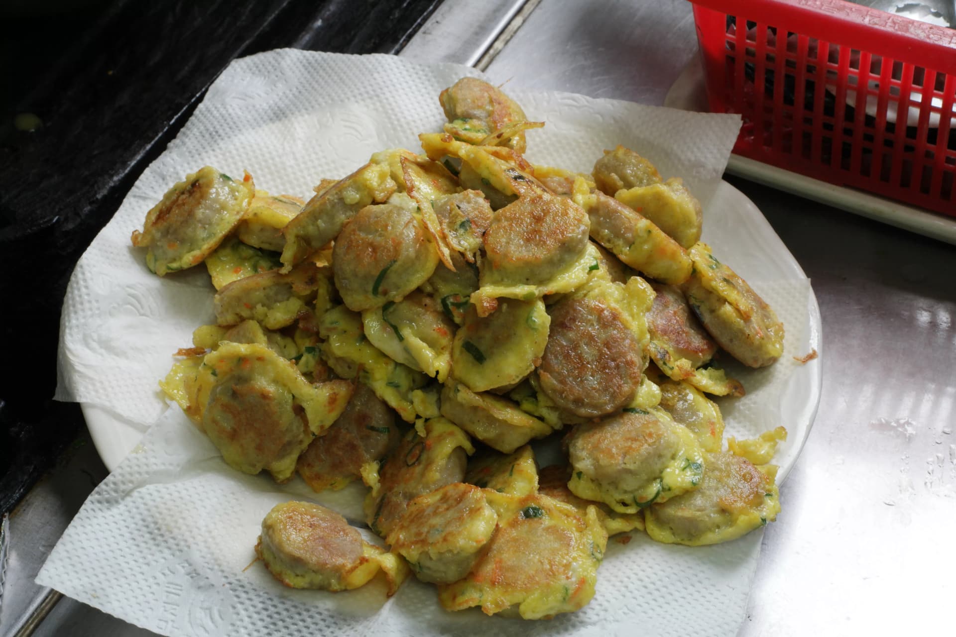 Batch of freshly fried Korean meat and tofu patties draining on kitchen paper towel