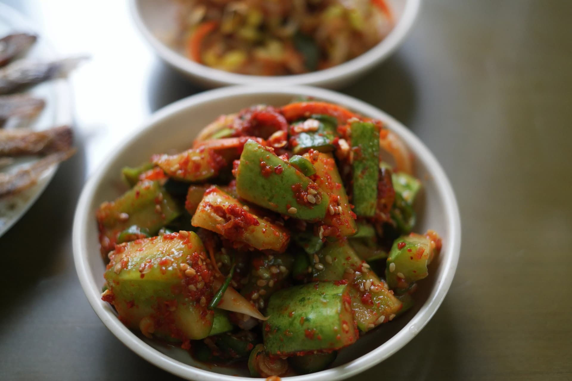 Chunky cucumber pieces tossed in red pepper flakes garlic and sesame in a Korean spicy cucumber salad