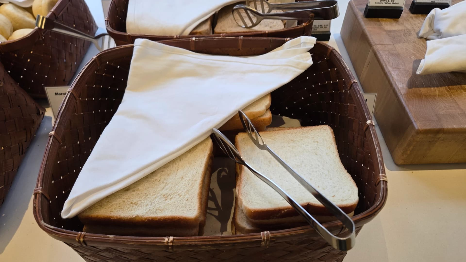 شرائح خبز أبيض بجانب المحمصة في ركن خبز بوفيه الفطور