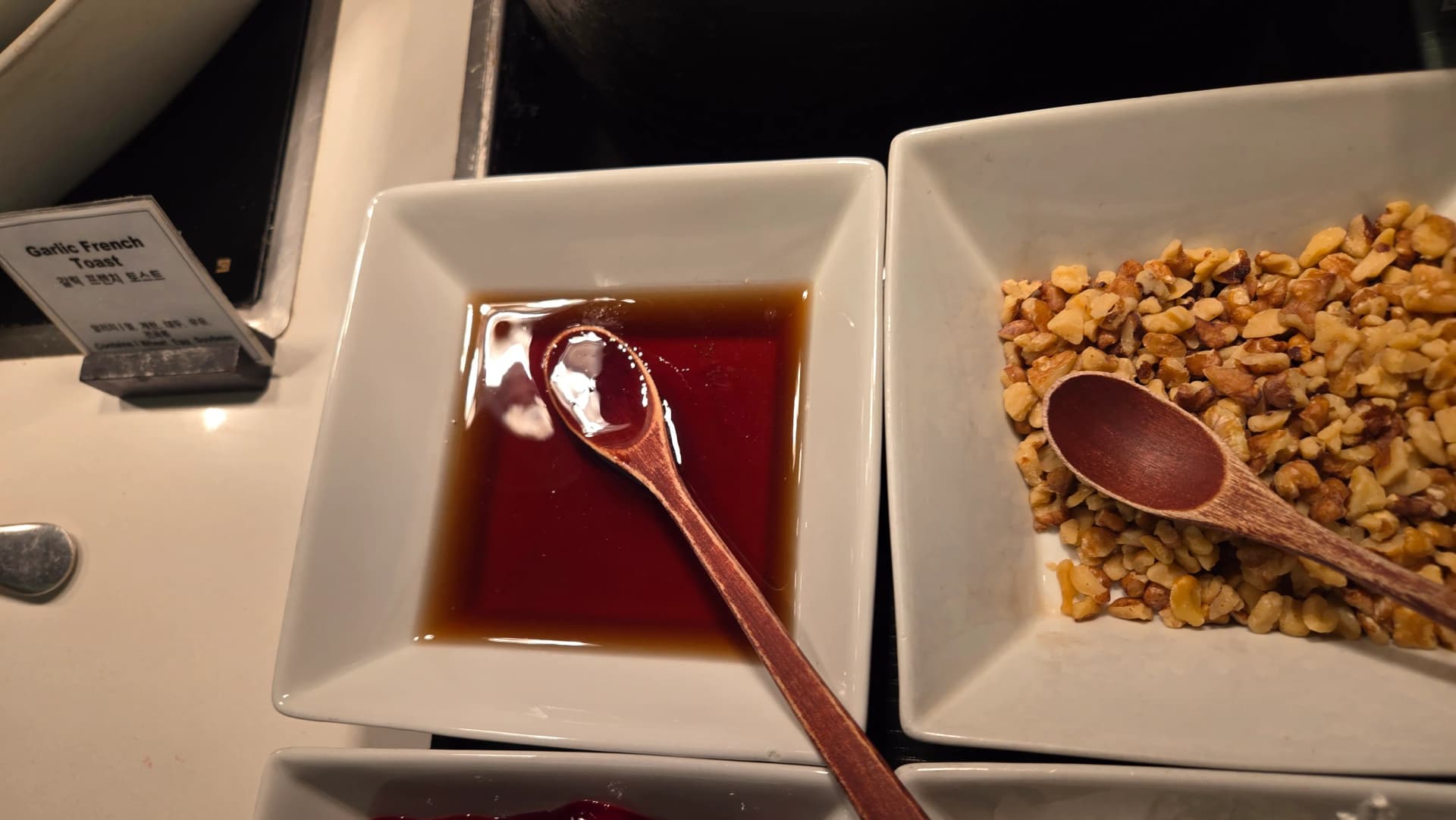 ركن إضافات الوافل في بوفيه الفطور مع كريمة وشراب قيقب وجوز مفروم